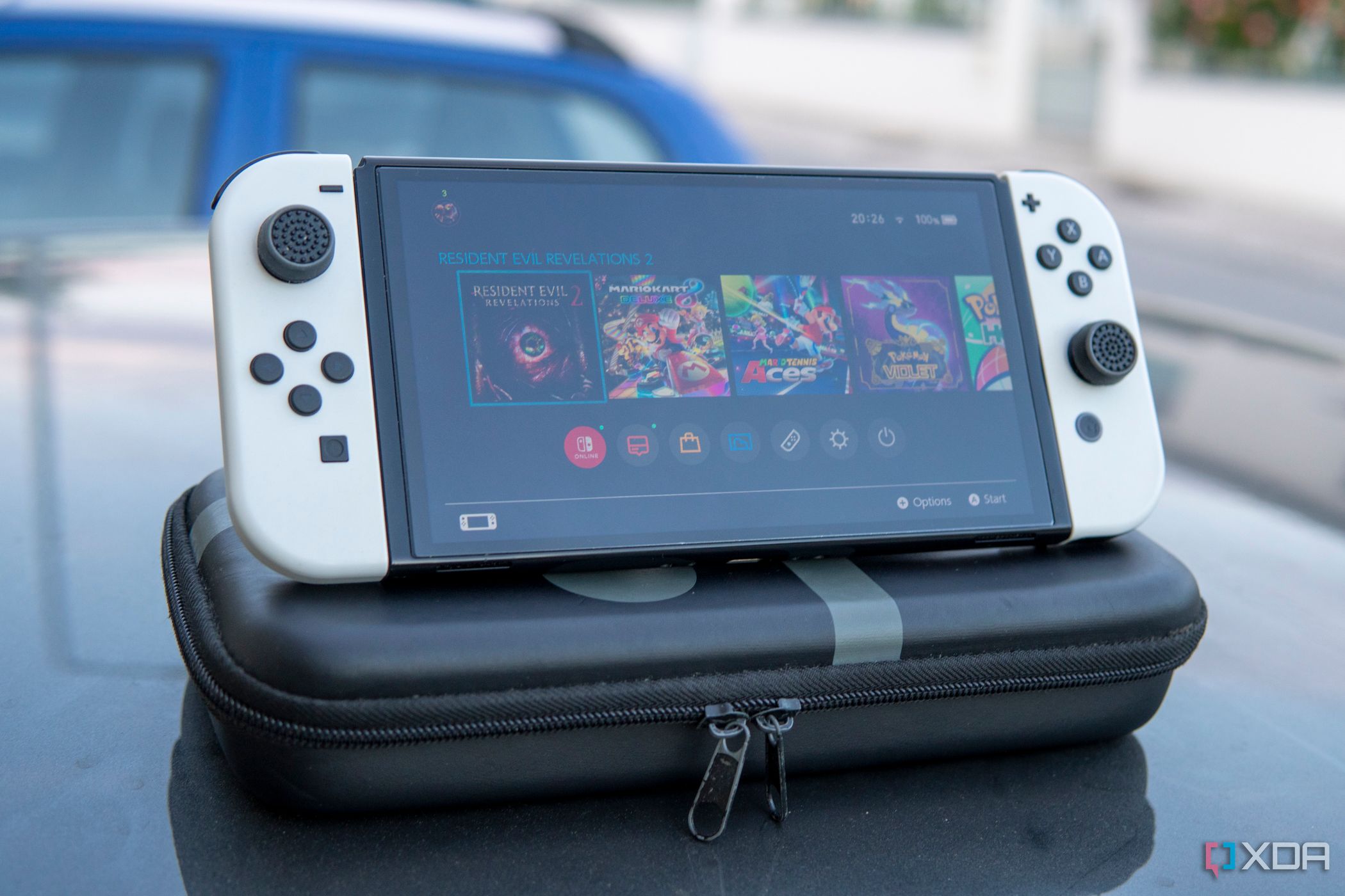 A Nintendo Switch OLED model standing on top of a carrying case