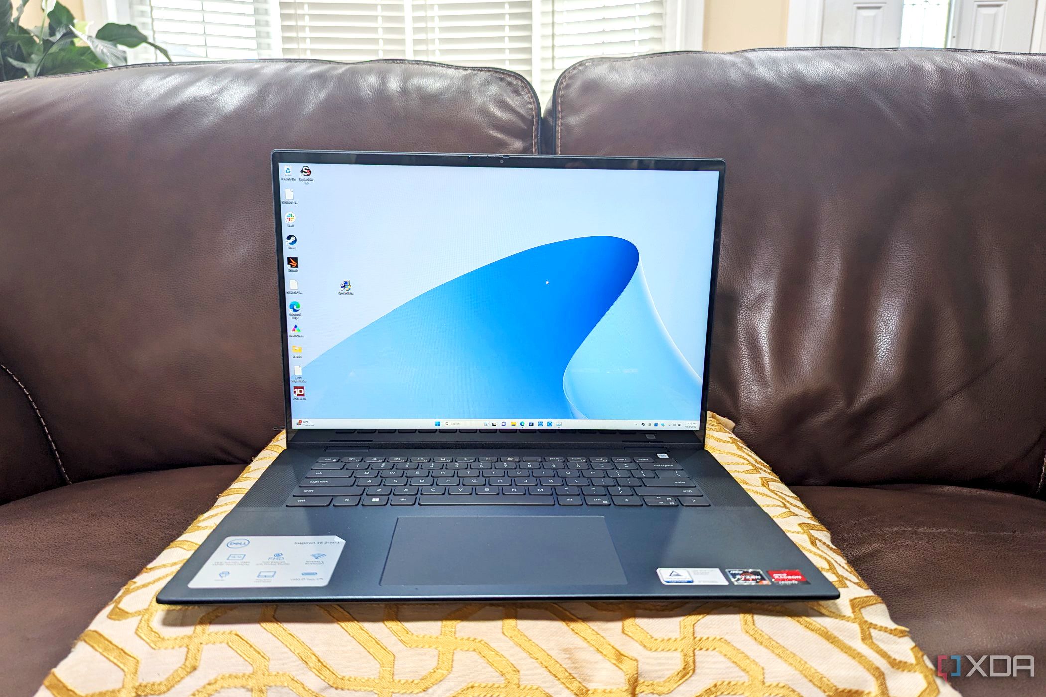 Dell Inspiron 16 2-in-1 sitting on a pillow on a sofa