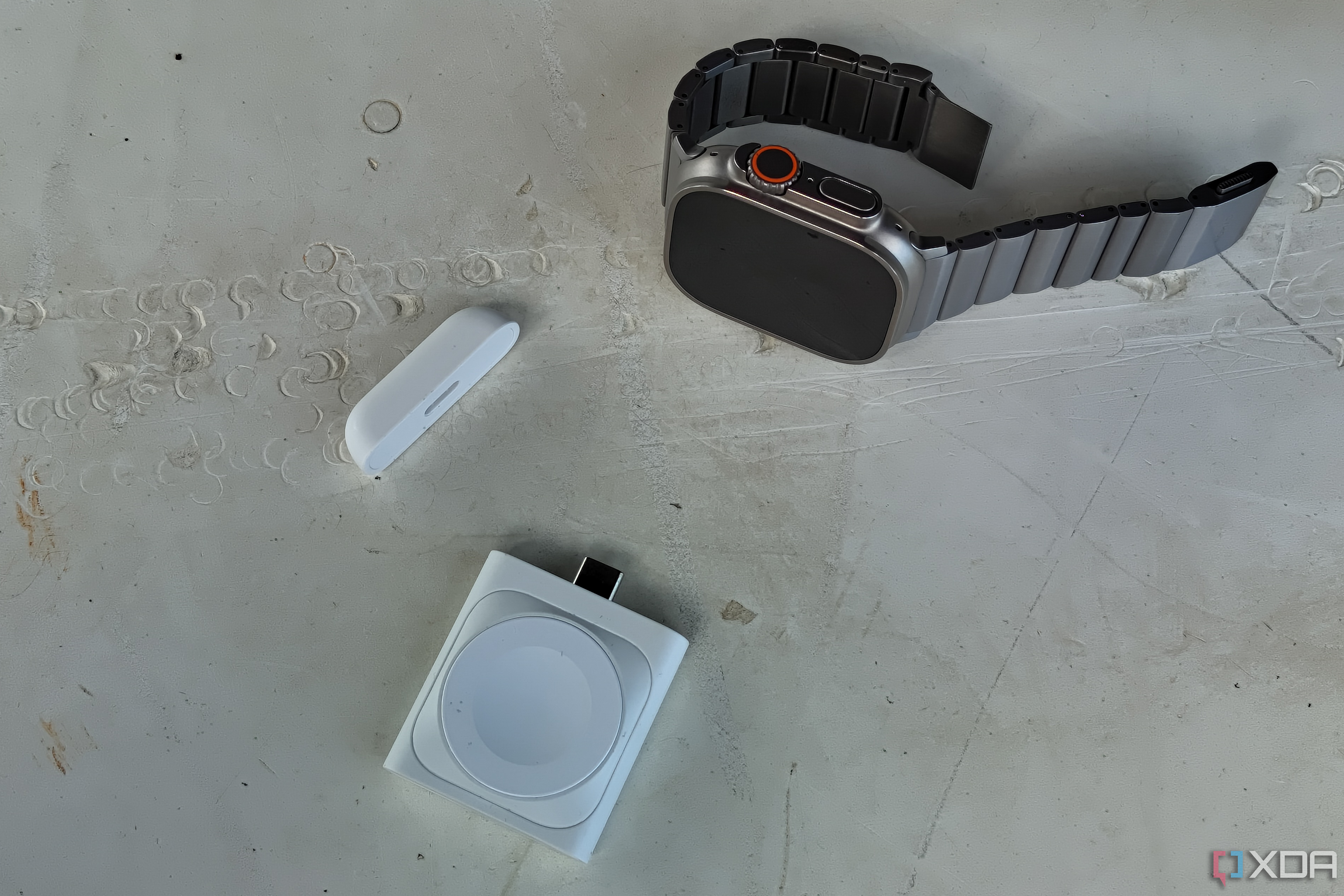 ESR's detachable Apple Watch charging puck beside an Apple Watch Ultra.