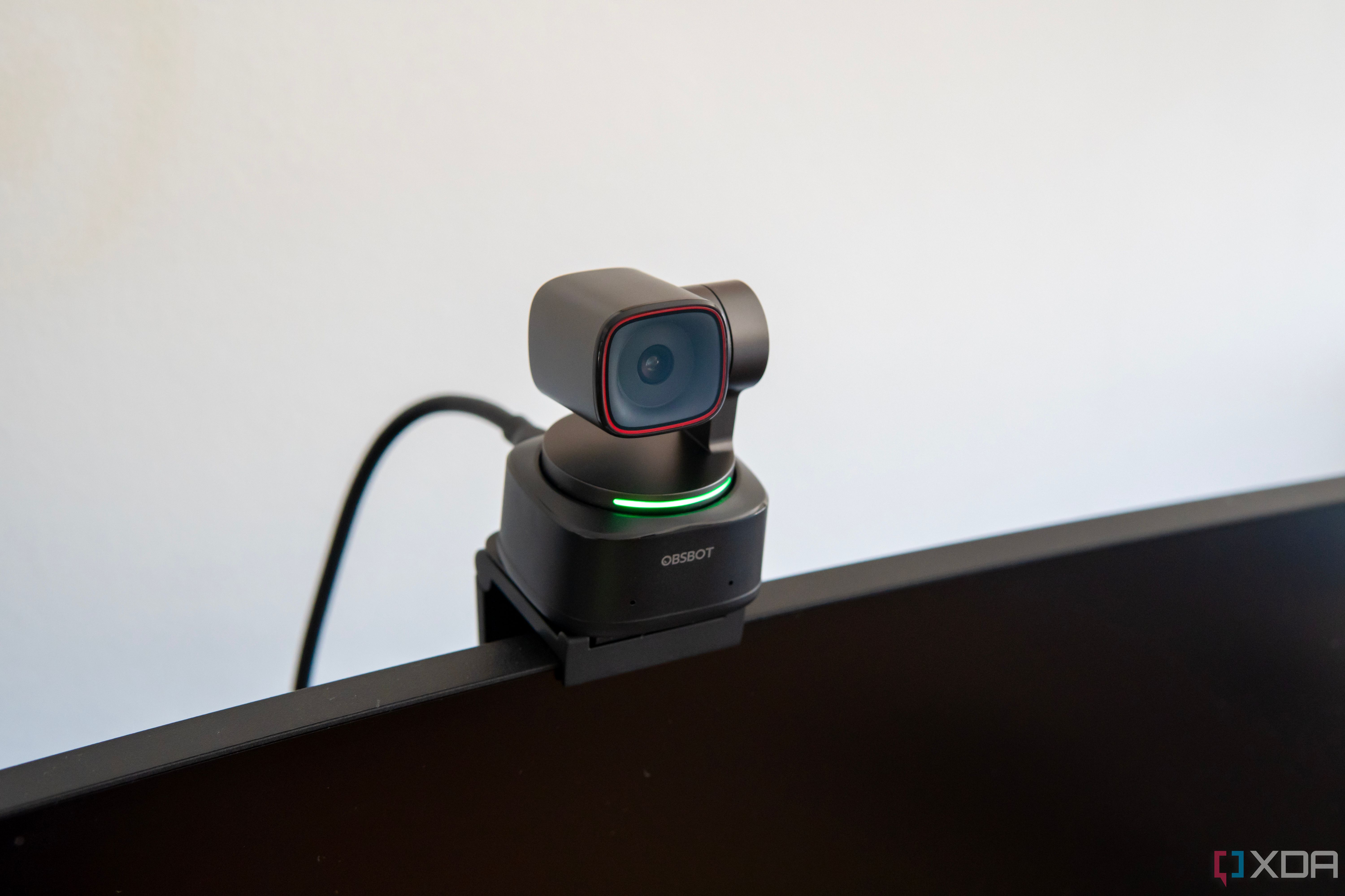 Front angled view of the Obsbot Tiny 2 webcam seen from the left mounted on a monitor