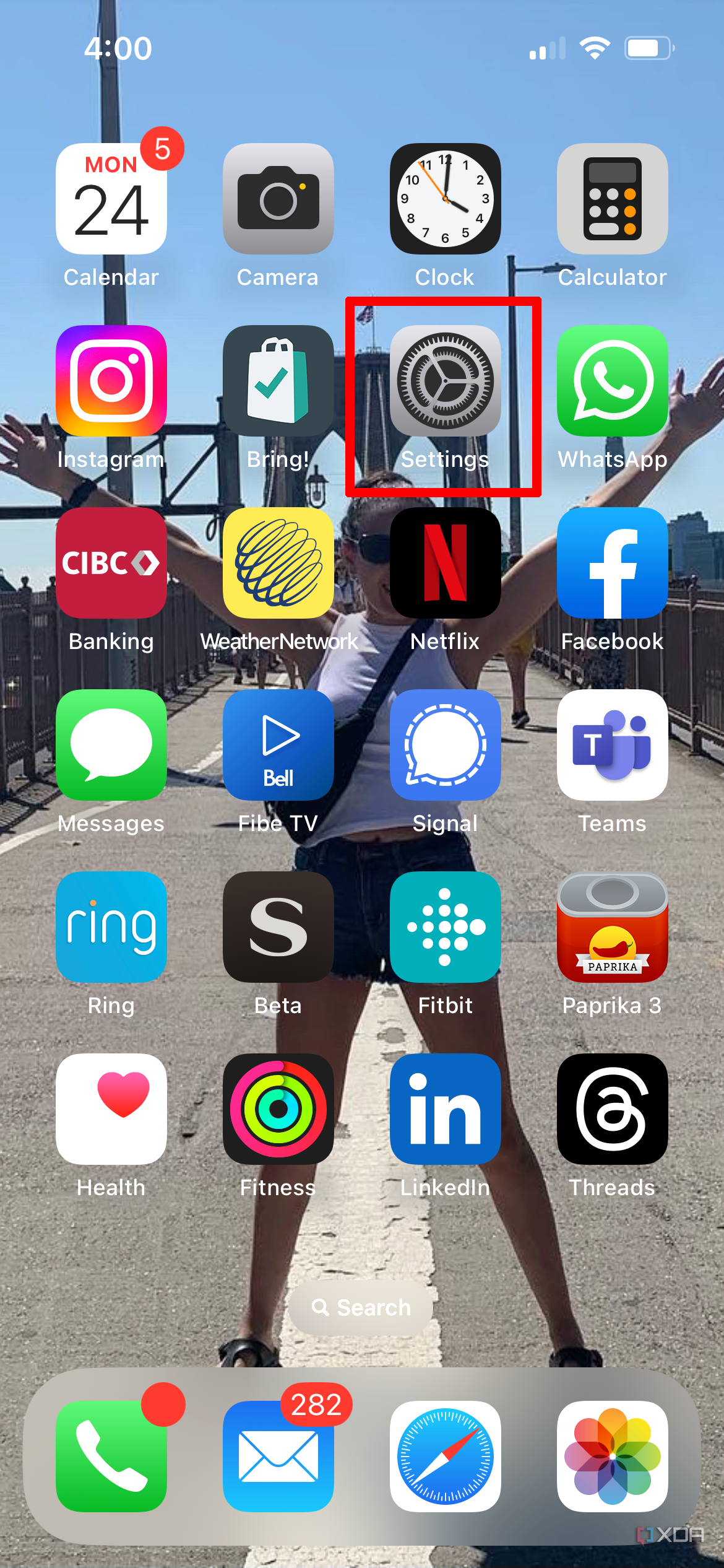 An iPhone home screen with the Settings icon selected.