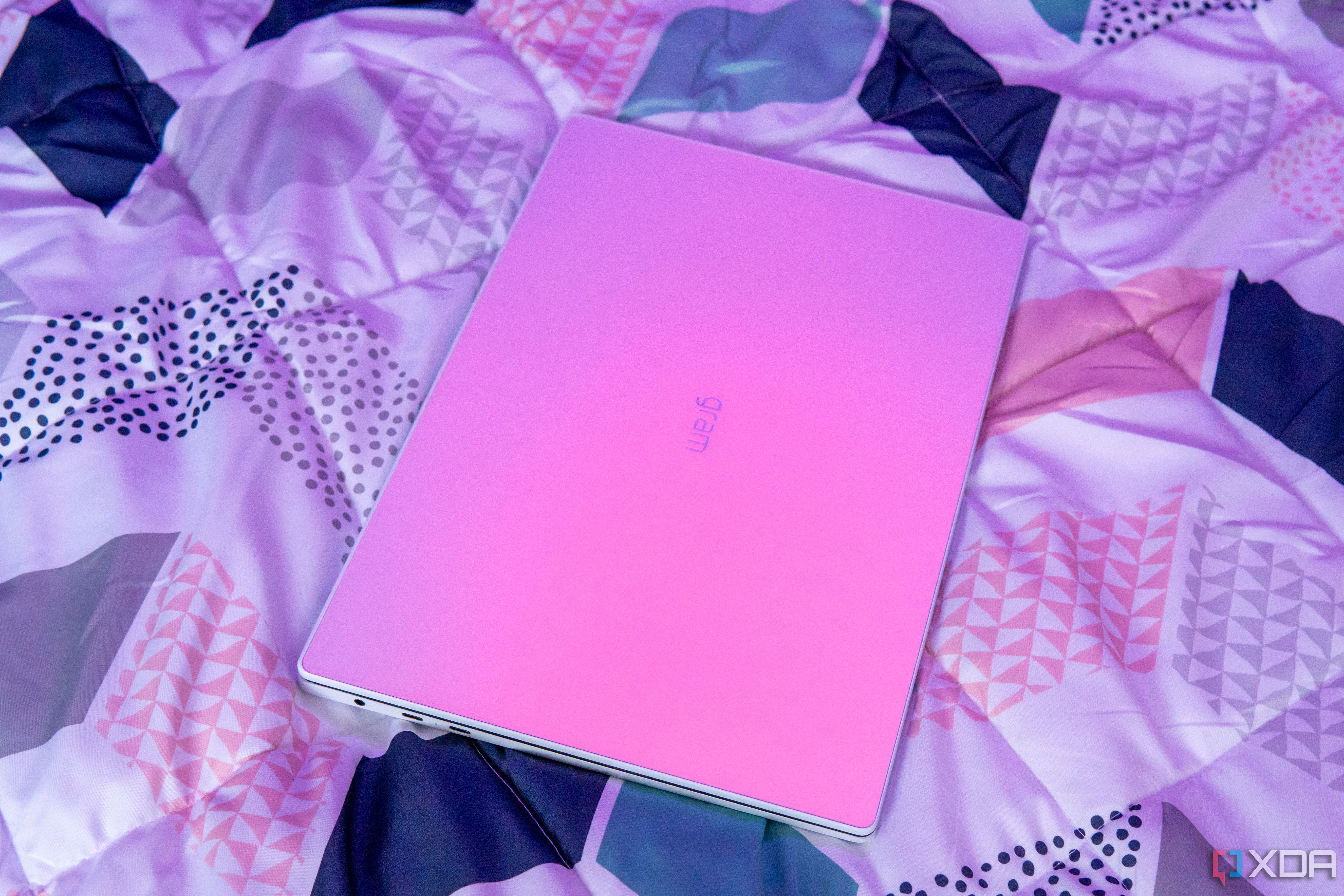 Angled view of the LG Gram Style under a pink light source, causing the glass surface to gain a pink hue