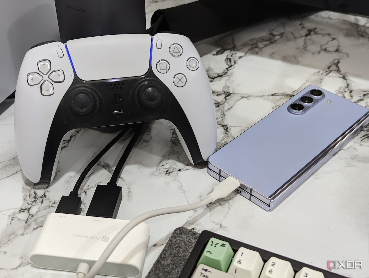 Изображение: контроллер PS5 DualSense, расположенный рядом с Galaxy З Fold 5 и клавиатура.