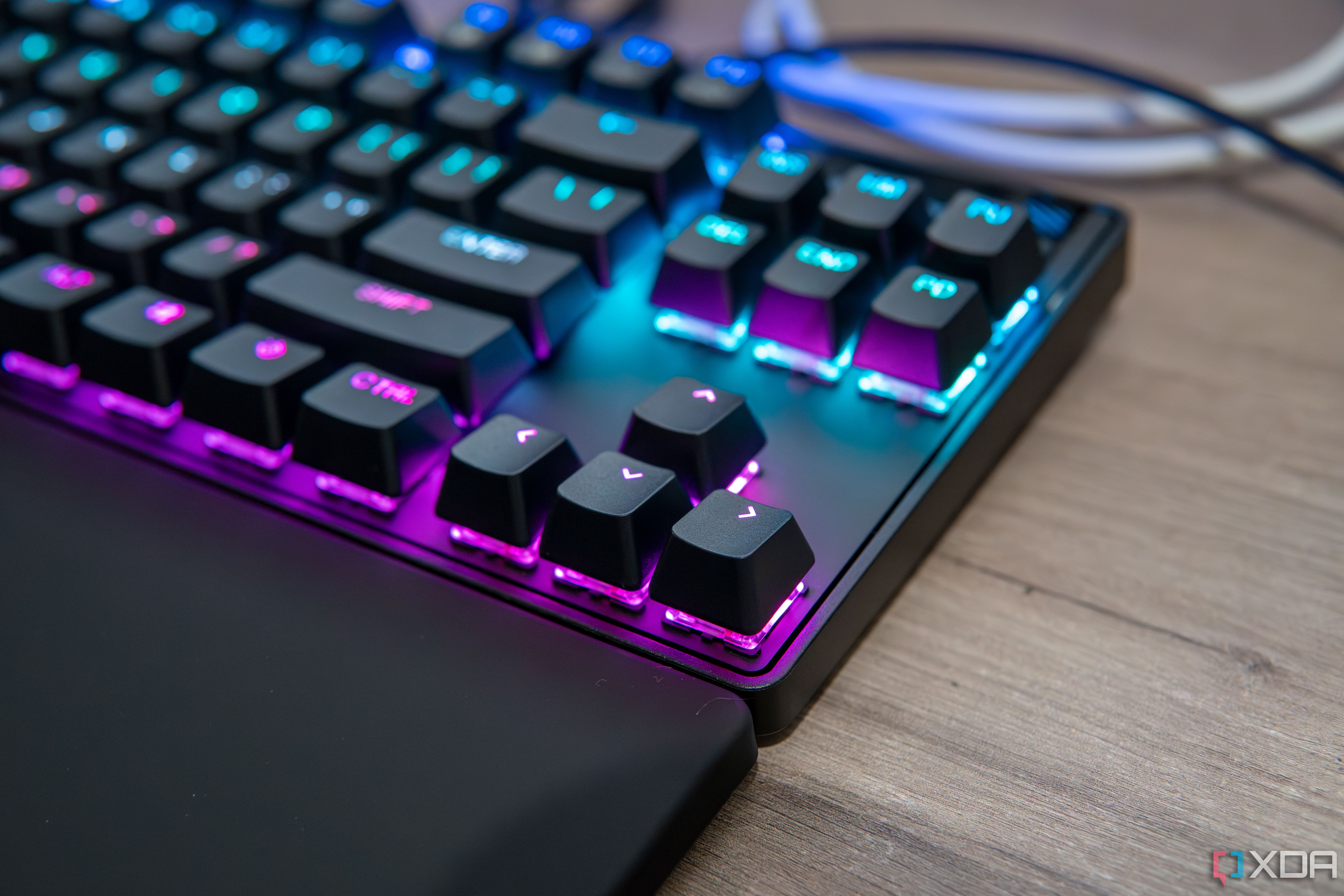 Nahaufnahme der Pfeiltasten einer SteelSeries Apex Pro TKL-Tastatur mit RGB-Beleuchtung in Pink und Blau