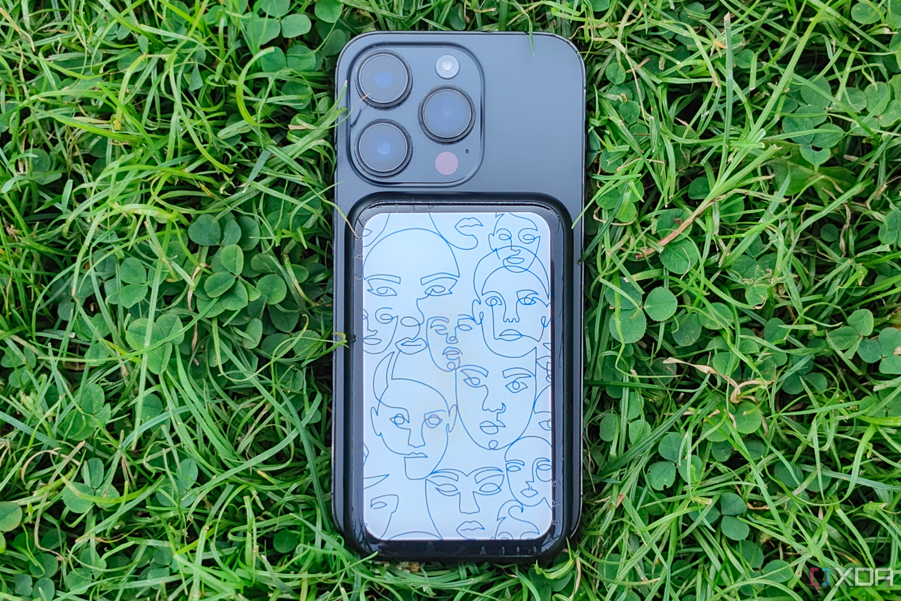 Casetify's PowerThru Power Bank connected to an iPhone 14 Pro on a grass background.