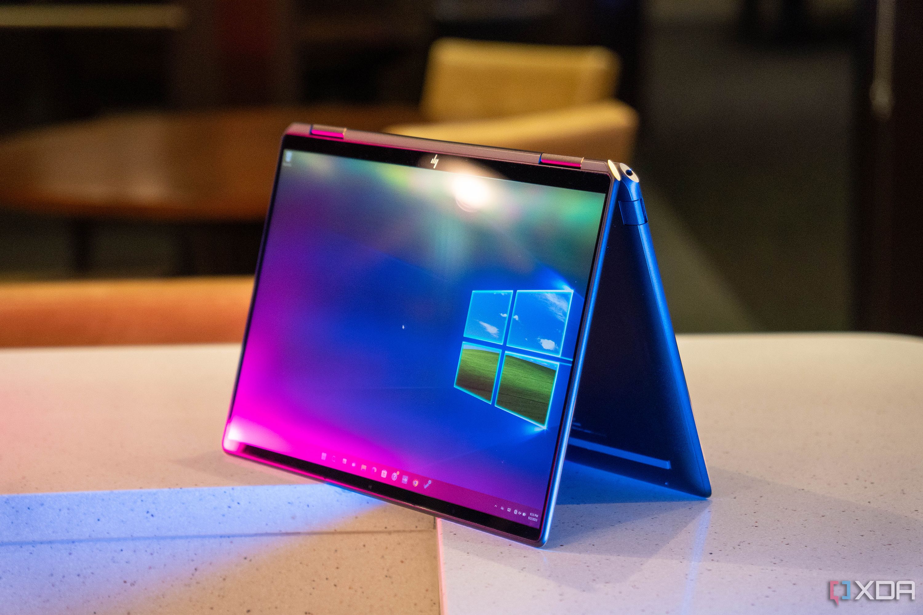 Convertible laptop on white counter with pink and blue lighting