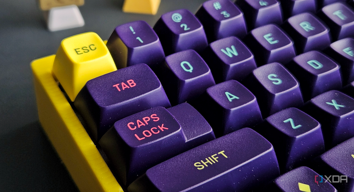 Uma imagem de um teclado mecânico com caixa amarela e teclas MT3 roxas.