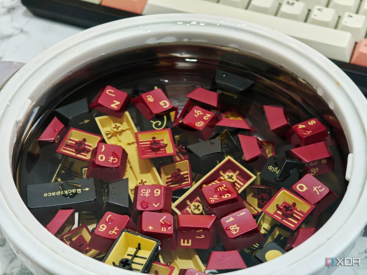 Una imagen que muestra las teclas GMK Red Samurai sumergidas en un recipiente con agua tibia.