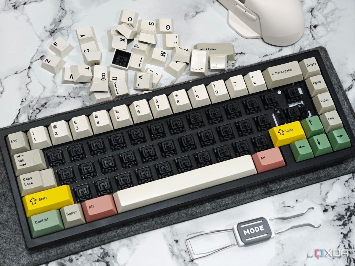 An image showing a mechanical keyboard with no alpha keys next to a keycap puller and a mouse.
