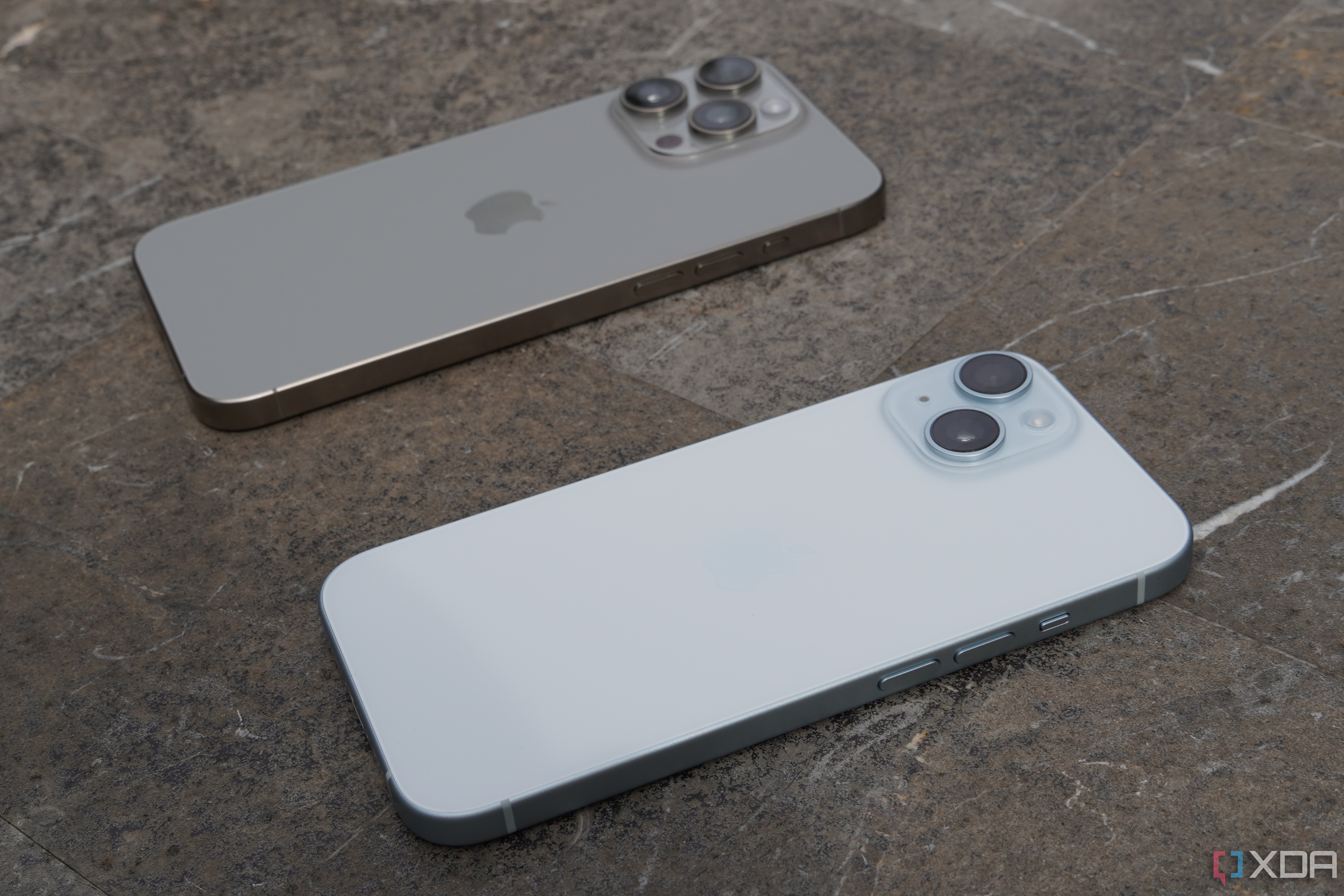 An iPhone 15 and iPhone 15 Pro Max on a tabletop.