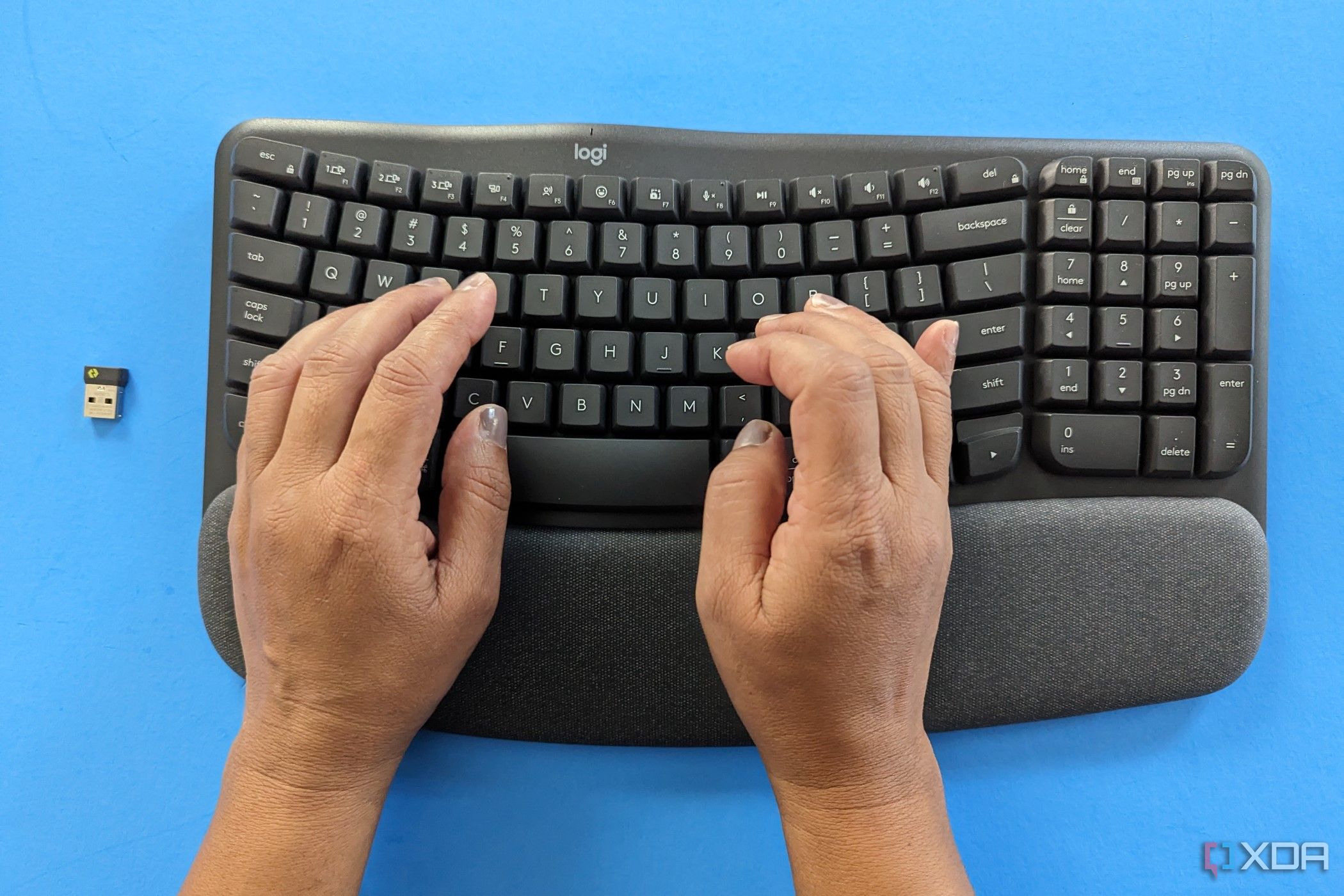 A woman's hands typing on the Logitech Wave Keys 
