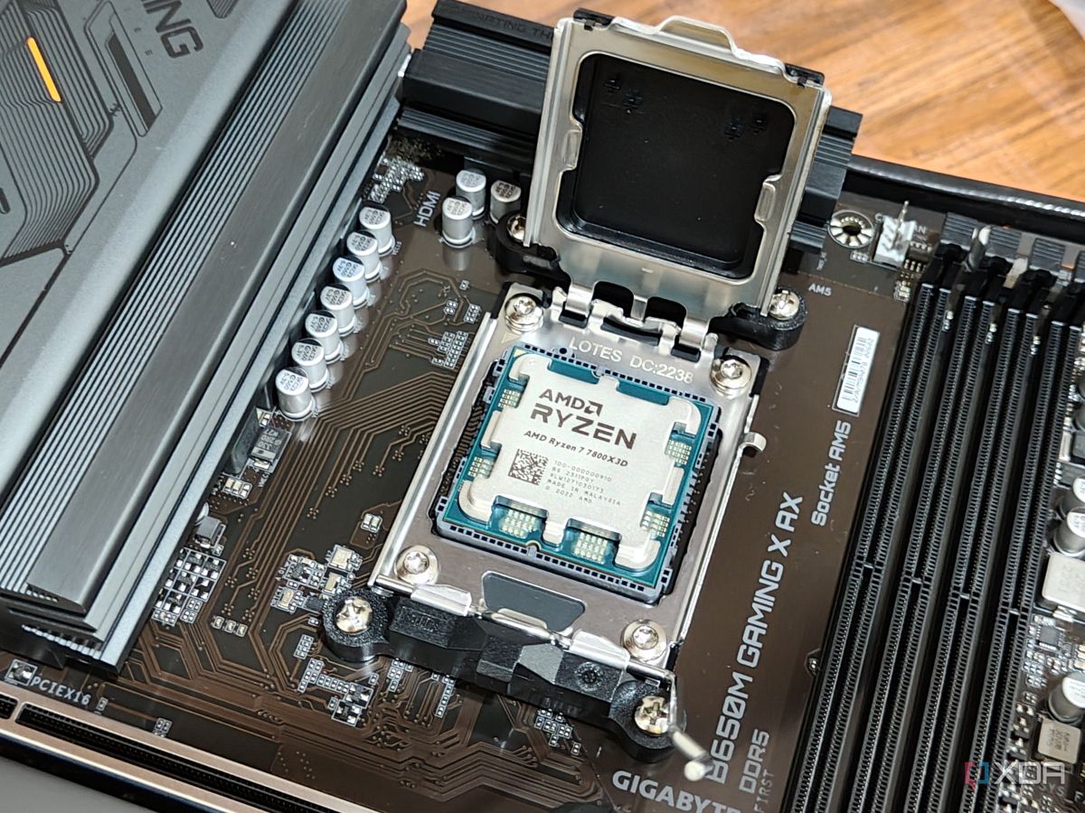 An image showing a Ryzen 7 7800X3D CPU resting on a motherboard's CPU socket.