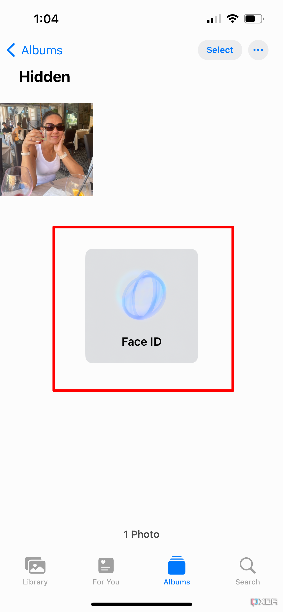 Скрытый iPhone альбом со всплывающим окном Face ID и изображением на заднем плане.