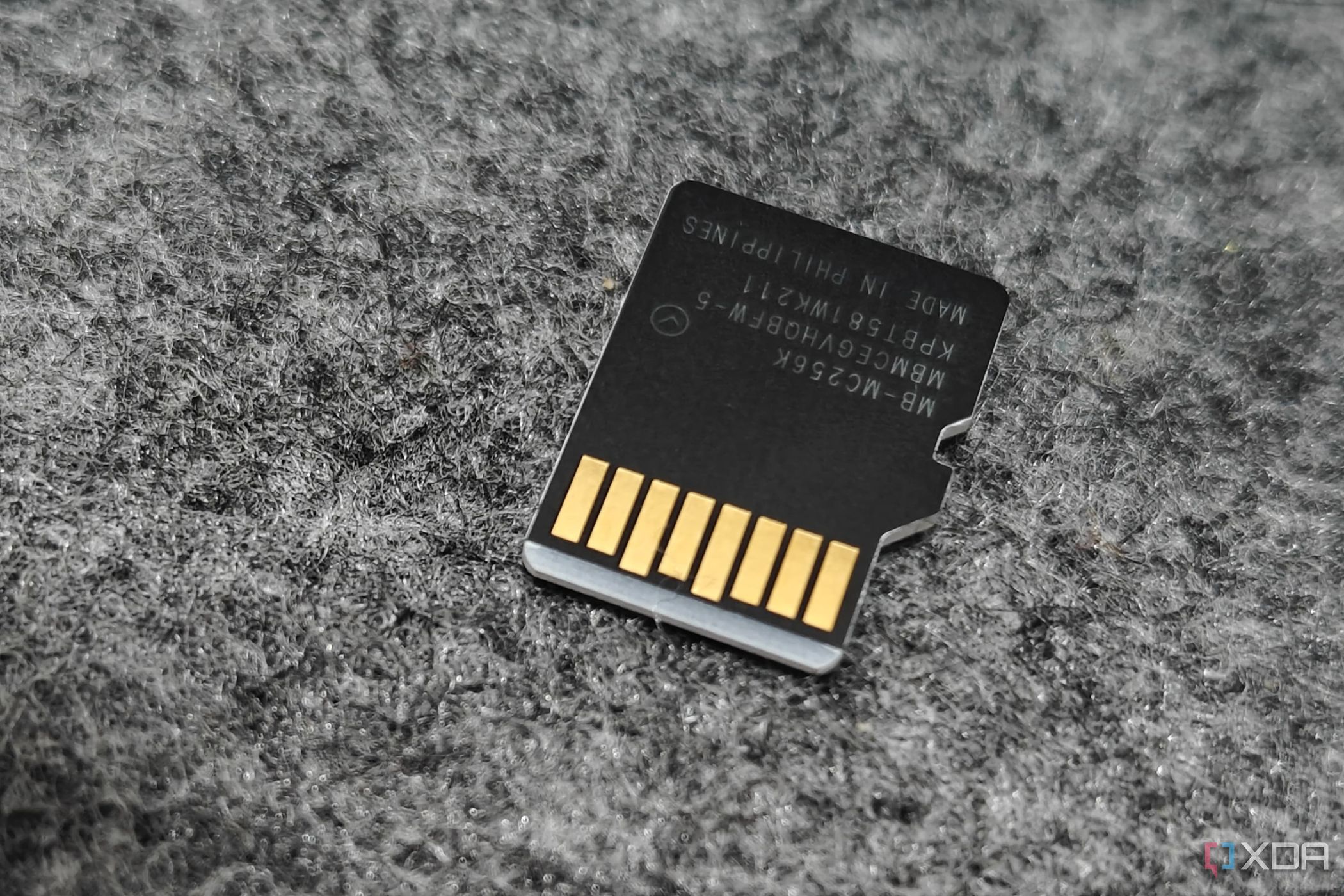 An image showing the back side of a microsd card kept on a felt deskmat.