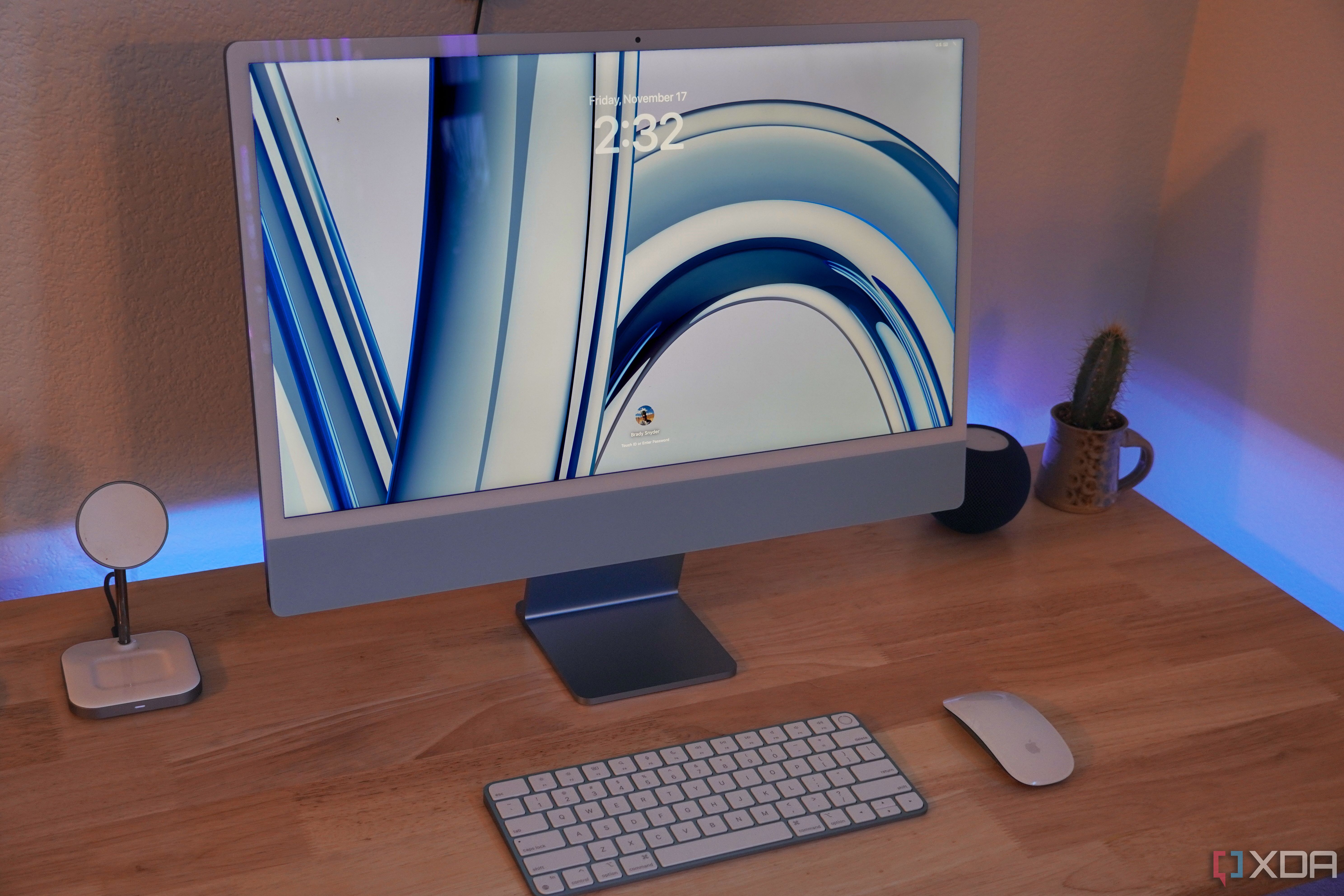 Un iMac M3 azul sobre un escritorio con periféricos y accesorios.