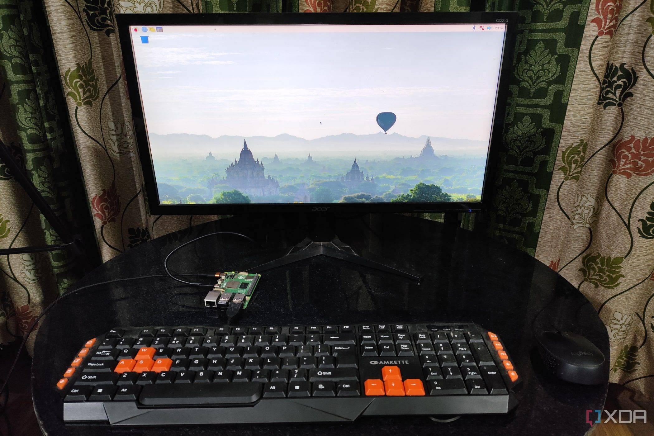 A Raspberry Pi 5 with a keyboard and mouse plugged in, with the monitor displaying the Raspberry Pi OS desktop