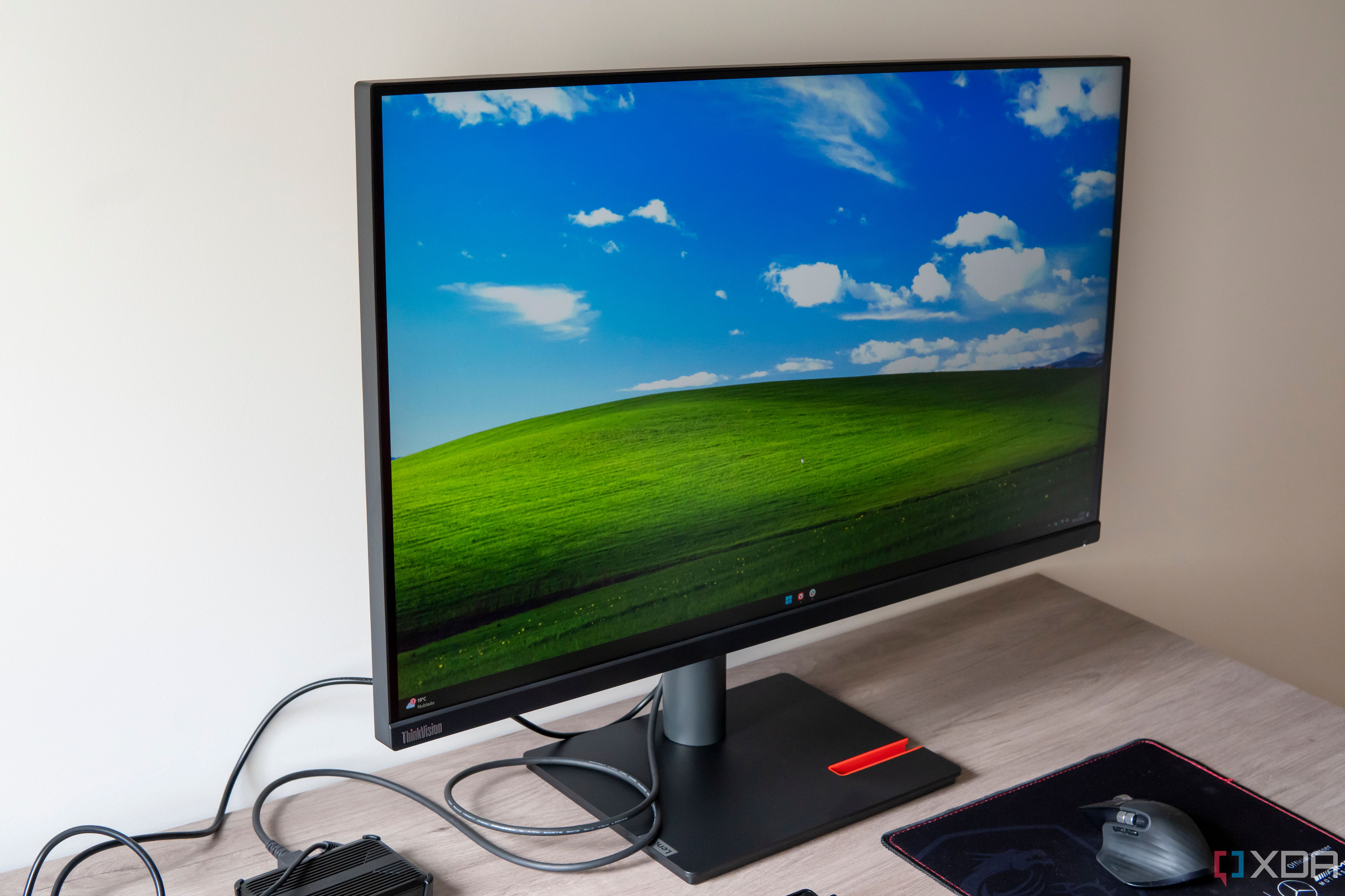 Angled front view of the Lenovo ThinkVision P32p-30 displaying a Windows 11 desktop with the Windows XP Bliss background