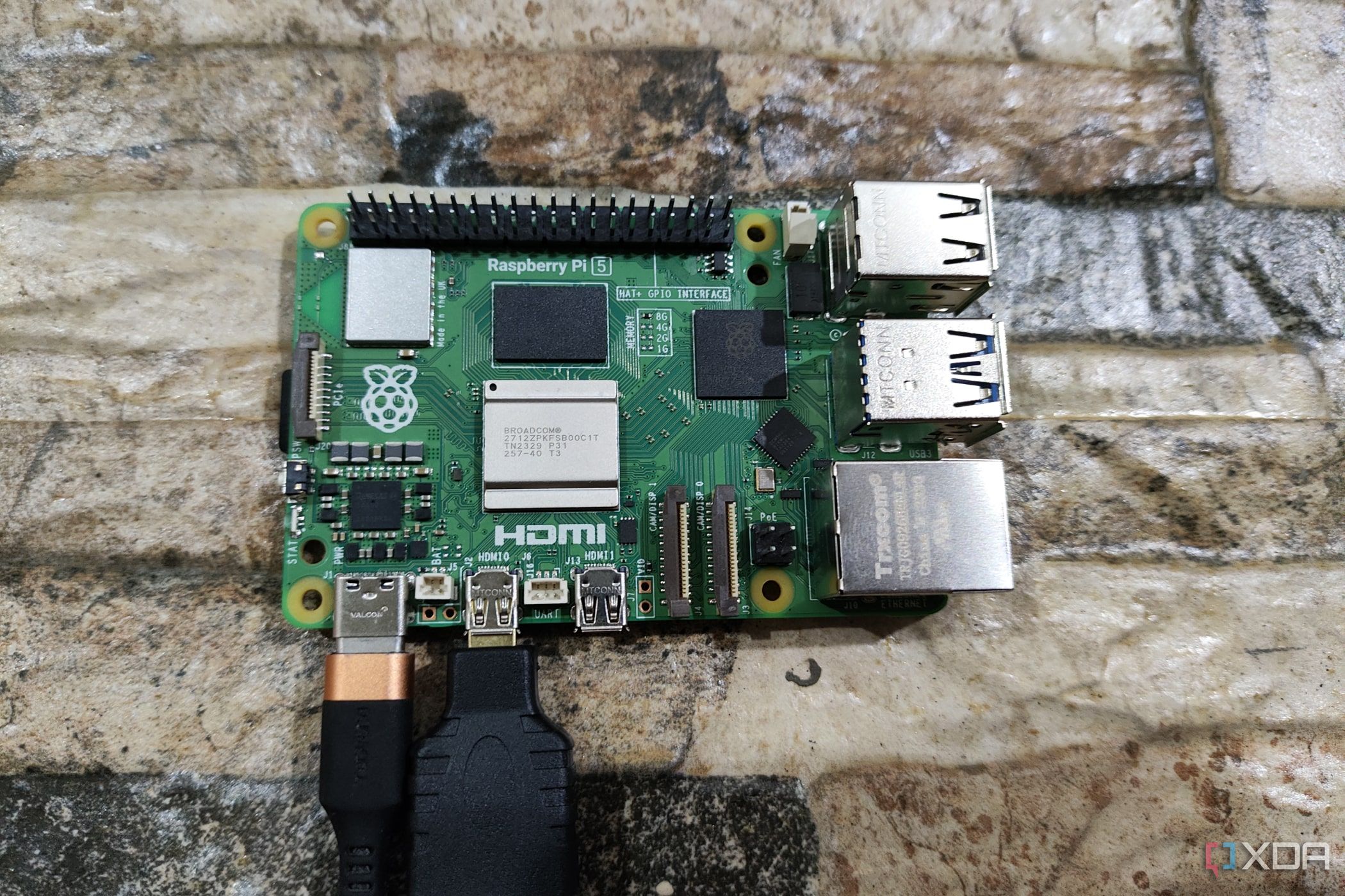 A Raspberry Pi 5 with a USB Type-C charging cable and a micro HDMI to HDMI adapter plugged in