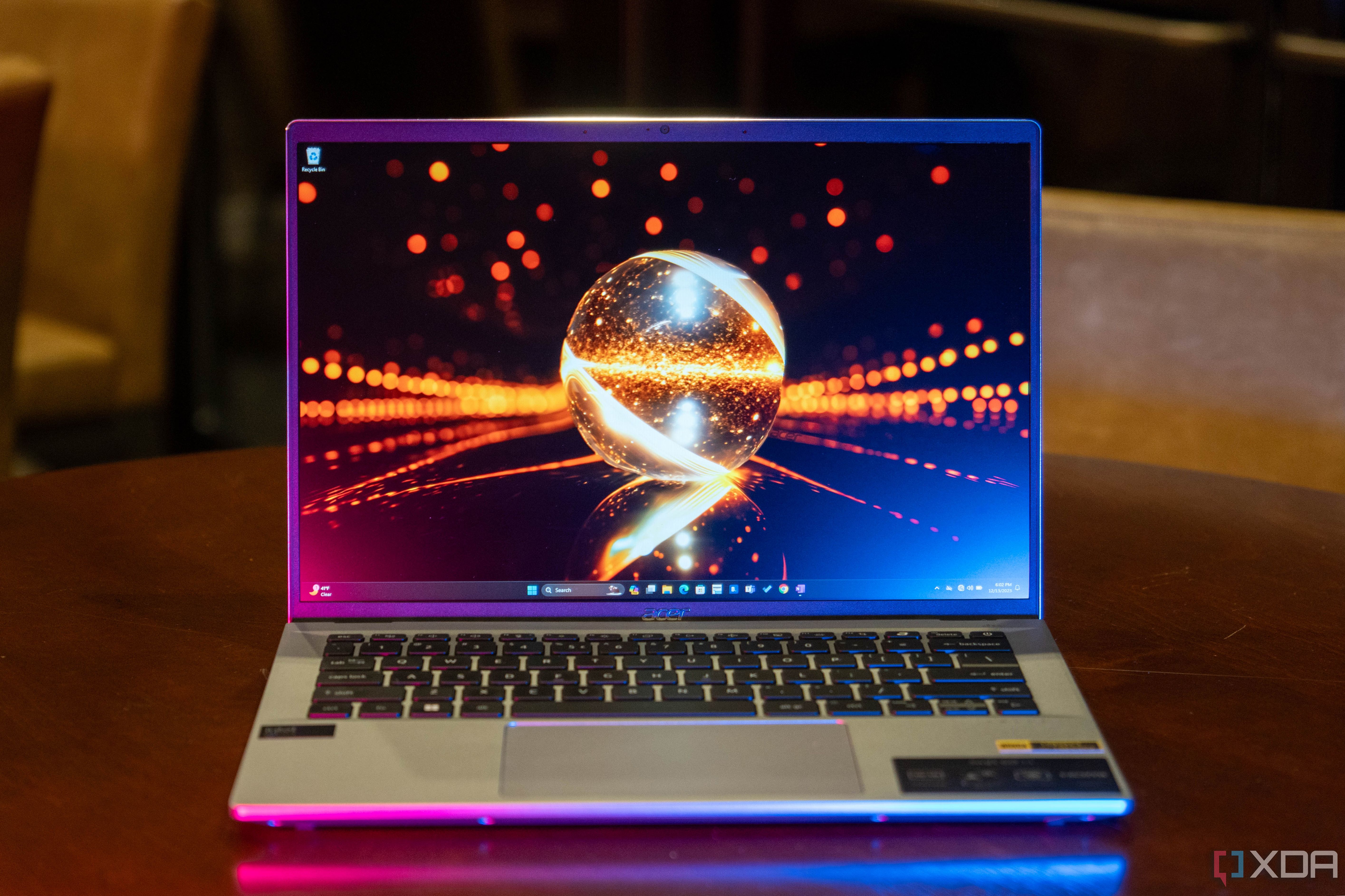 Acer Swift Go 14 sobre mesa de madera con iluminación rosa y azul