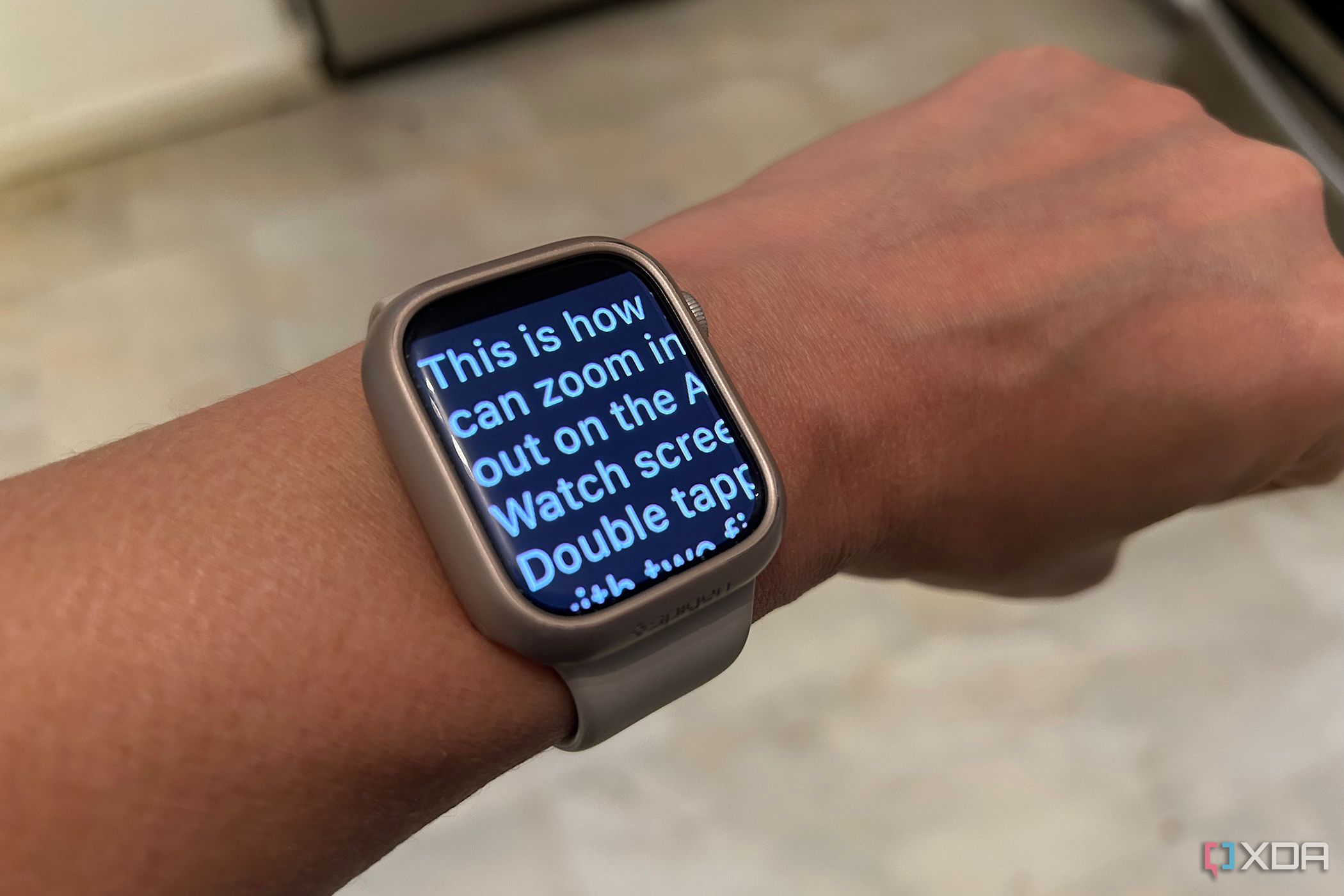 A wrist with an Apple Watch showing enlarged text.