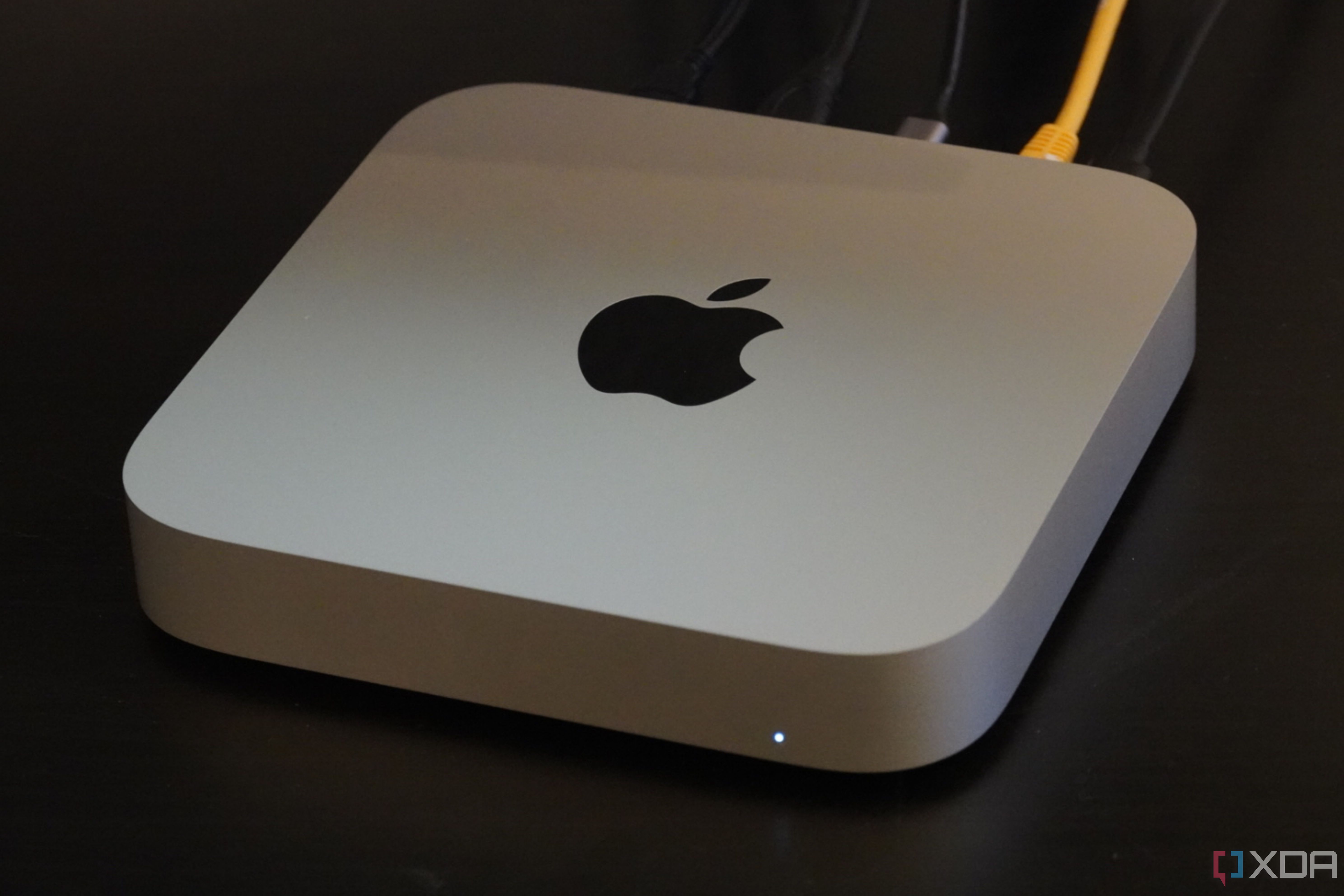 A Mac Mini on a desk with cables connected. 