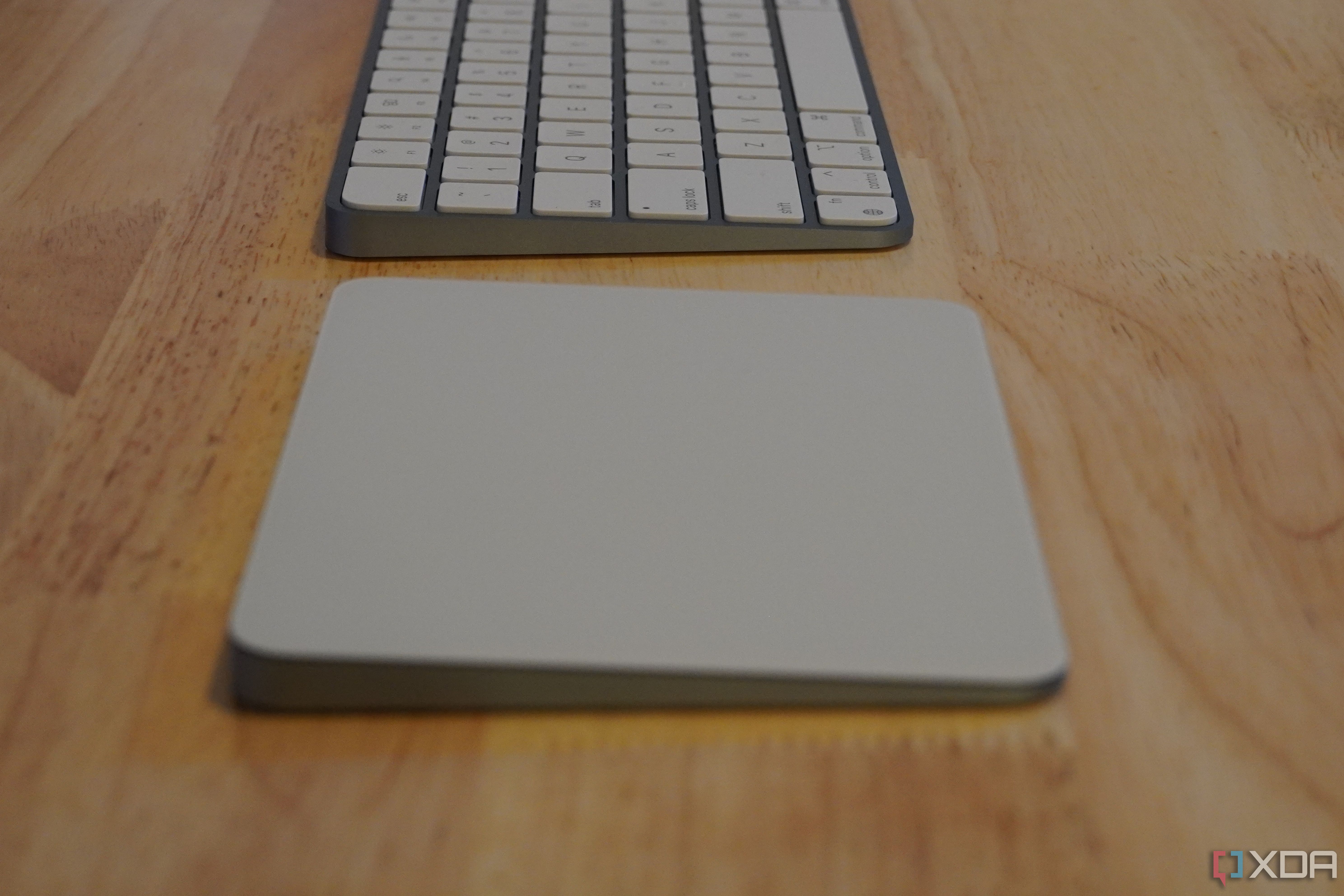 The side of a trackpad and keyboard on a desk.