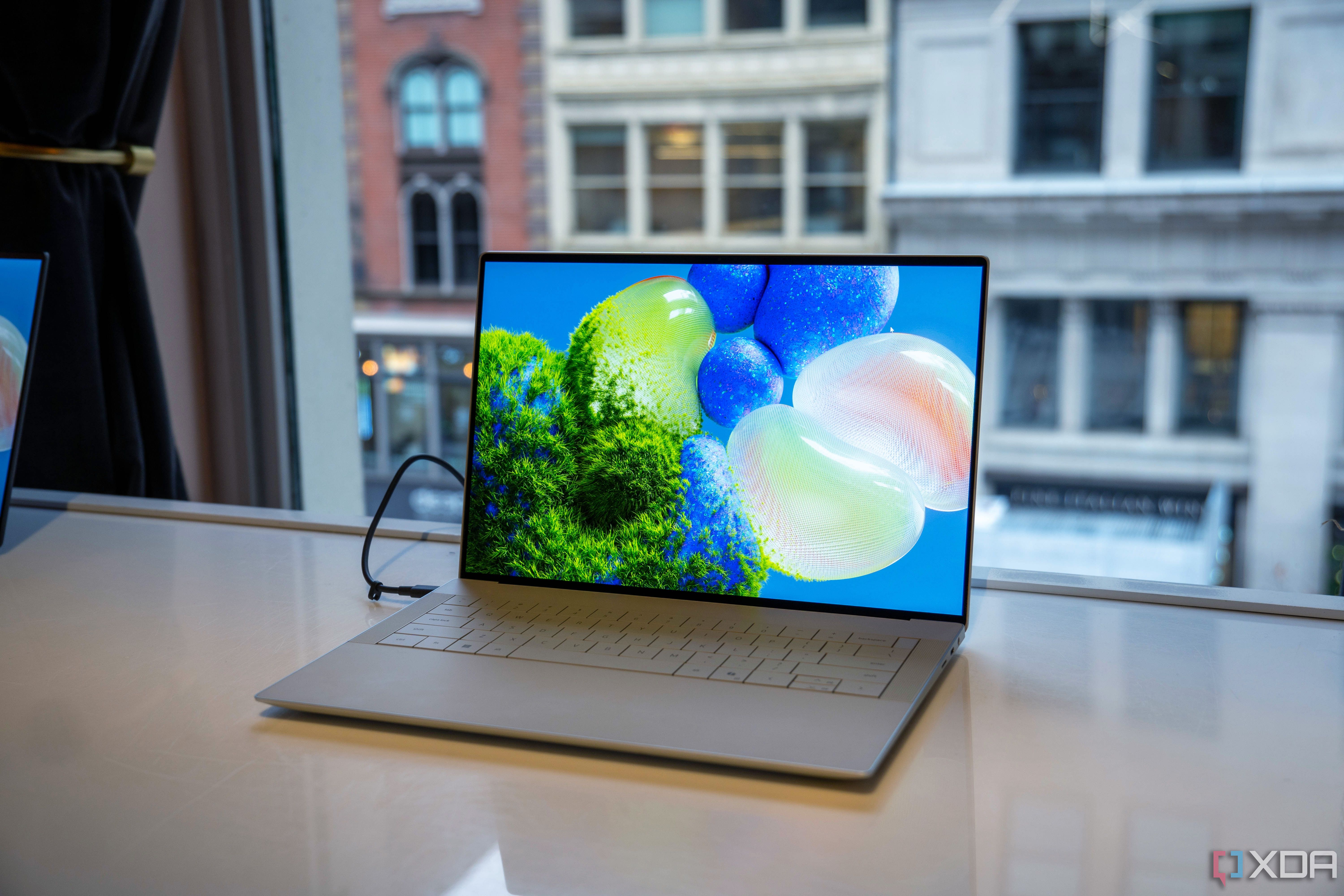 A Platinum Dell XPS 14 showing its screen; it sits in front of a window.