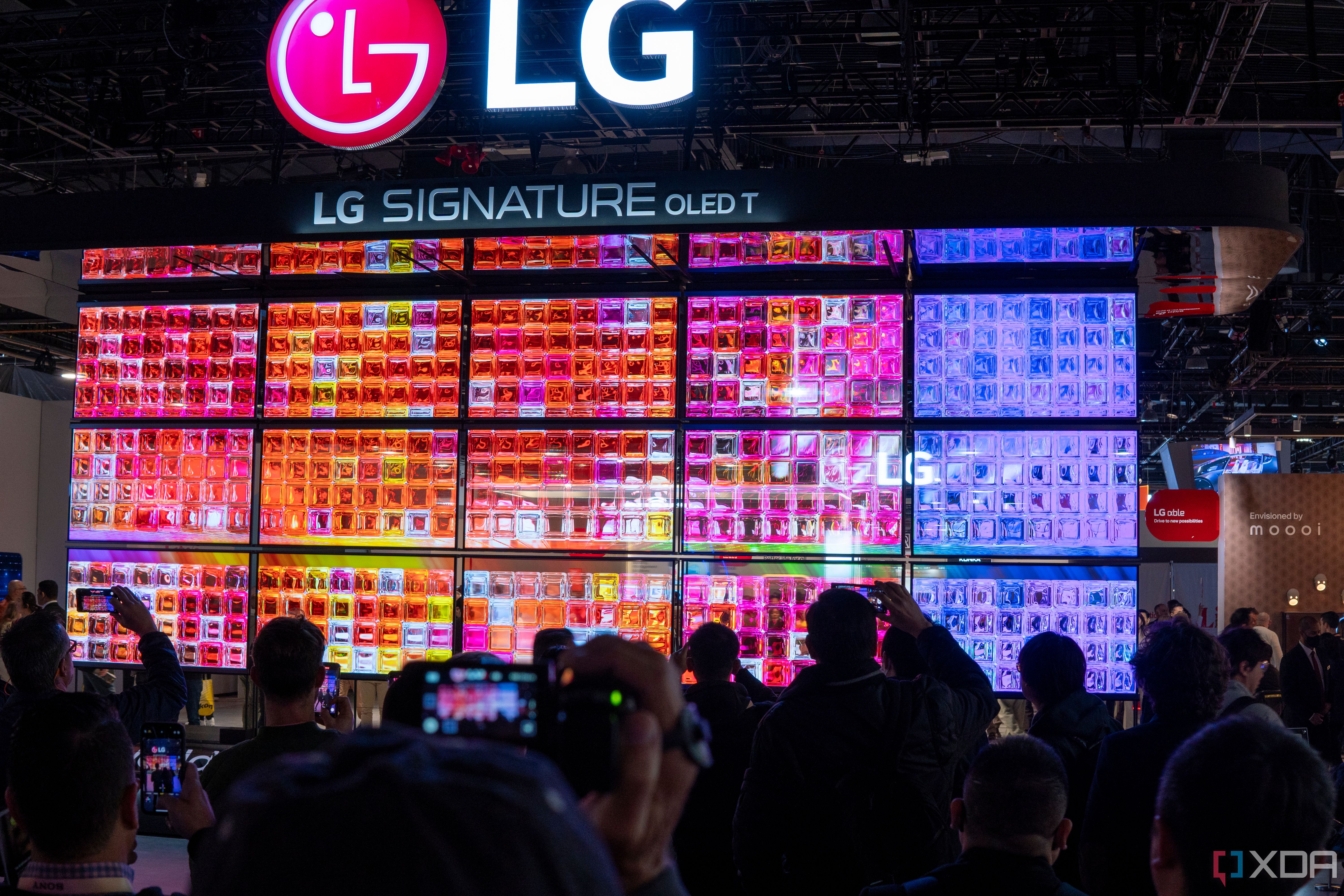 A wall of transparent OLED TVs showing colorful images
