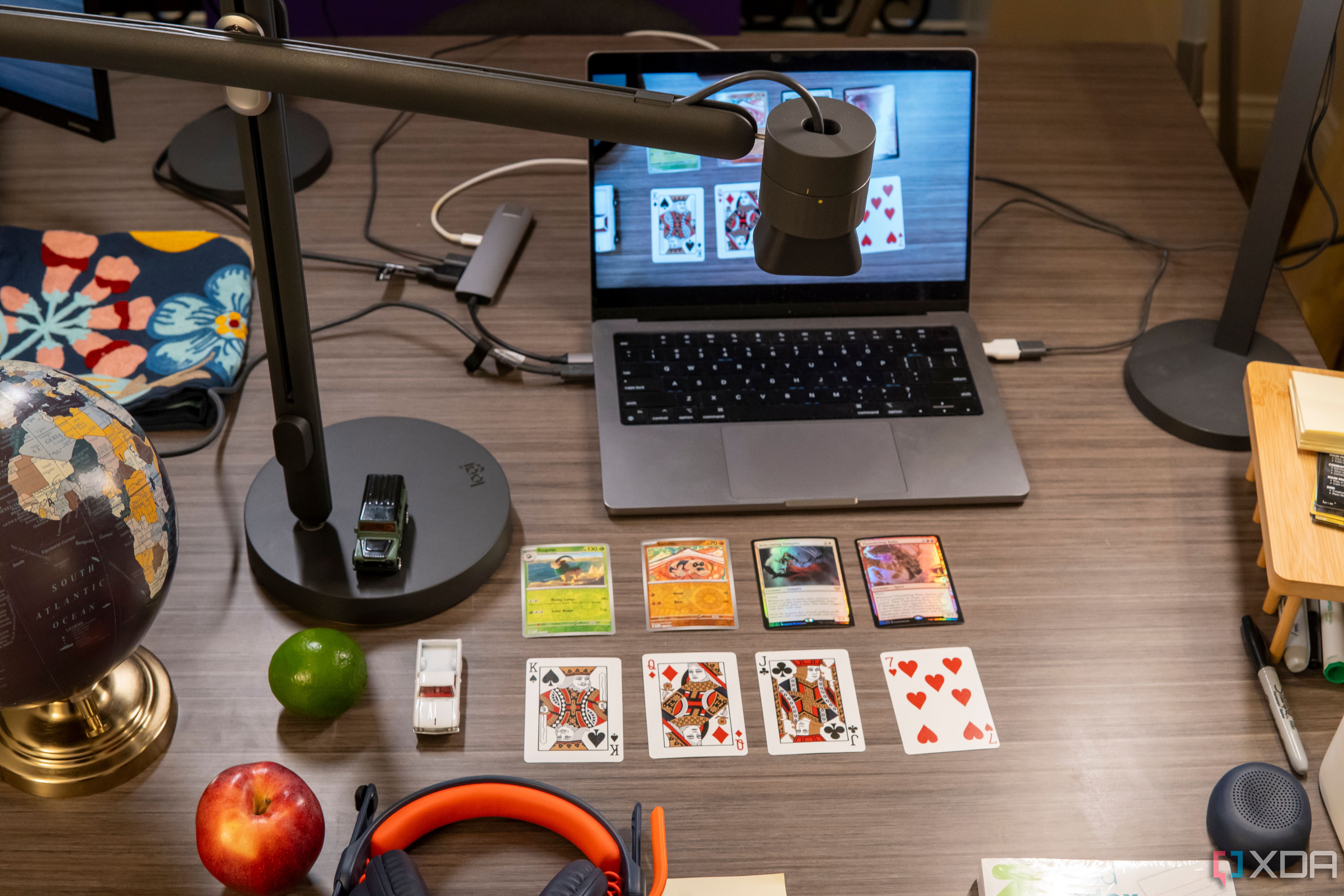 A desk with multiple cards and a Logitech Reach webcam pointing down at them