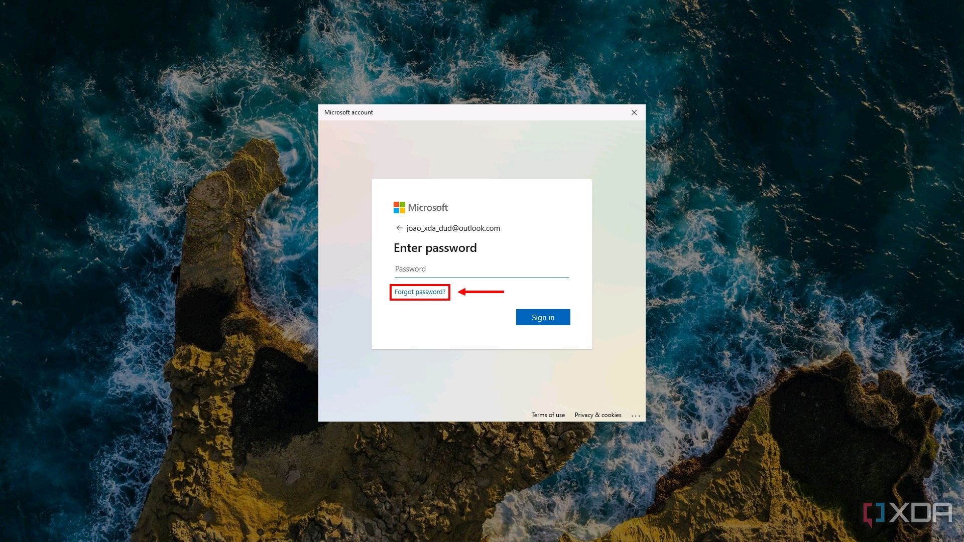 Captura de pantalla de la pantalla de inicio de sesión de Windows 11 que solicita al usuario una contraseña de cuenta Microsoft. El botón de contraseña olvidada está resaltado