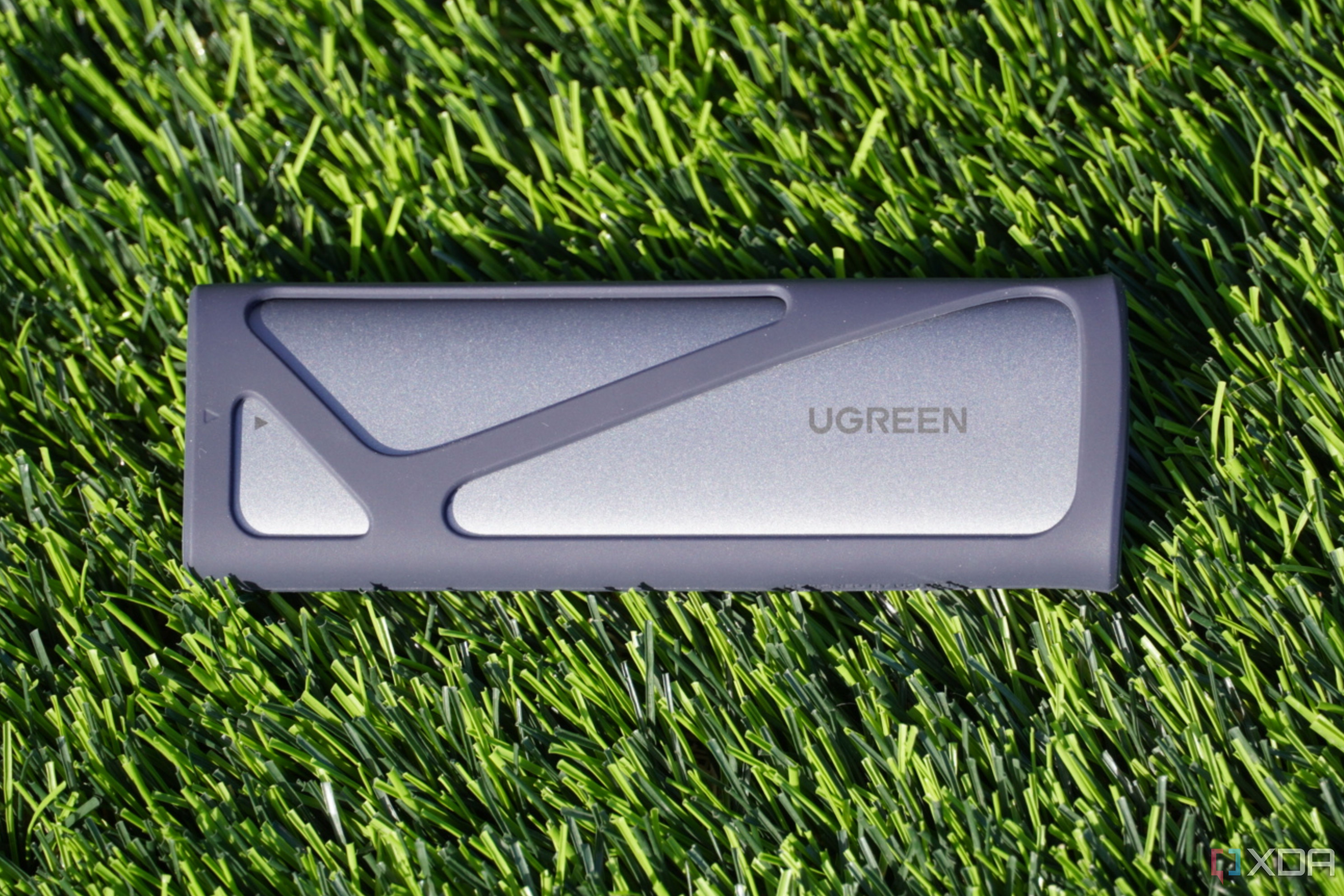 The UGreen SSD enclosure on a grass background.