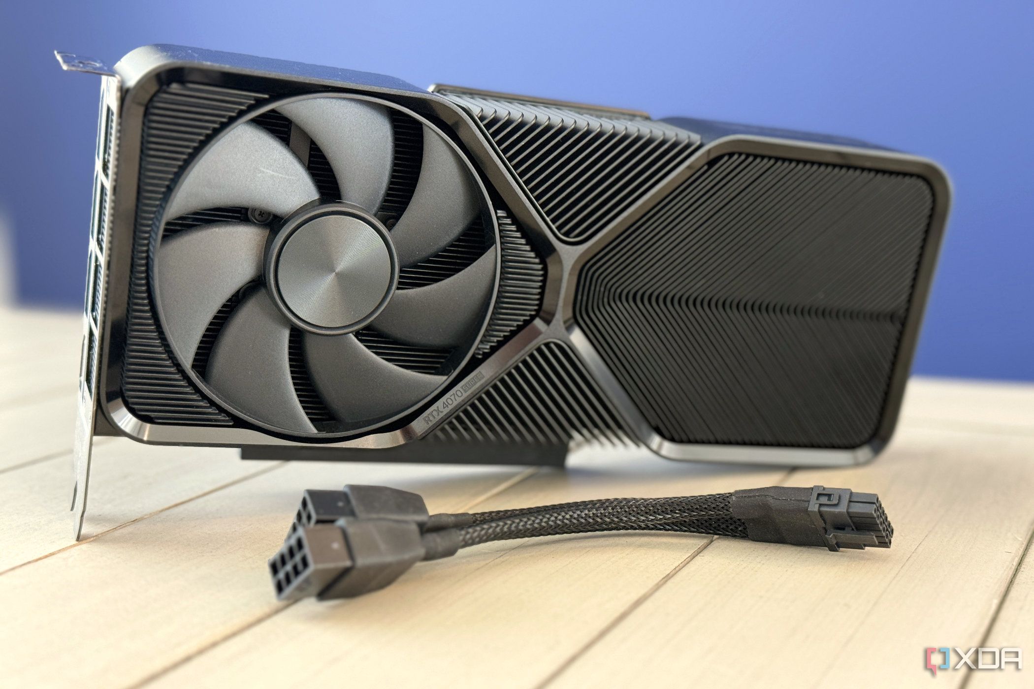 La Nvidia GeForce RTX 4070 Super Founders Edition se colocó sobre una mesa con el adaptador de corriente PCIe al frente