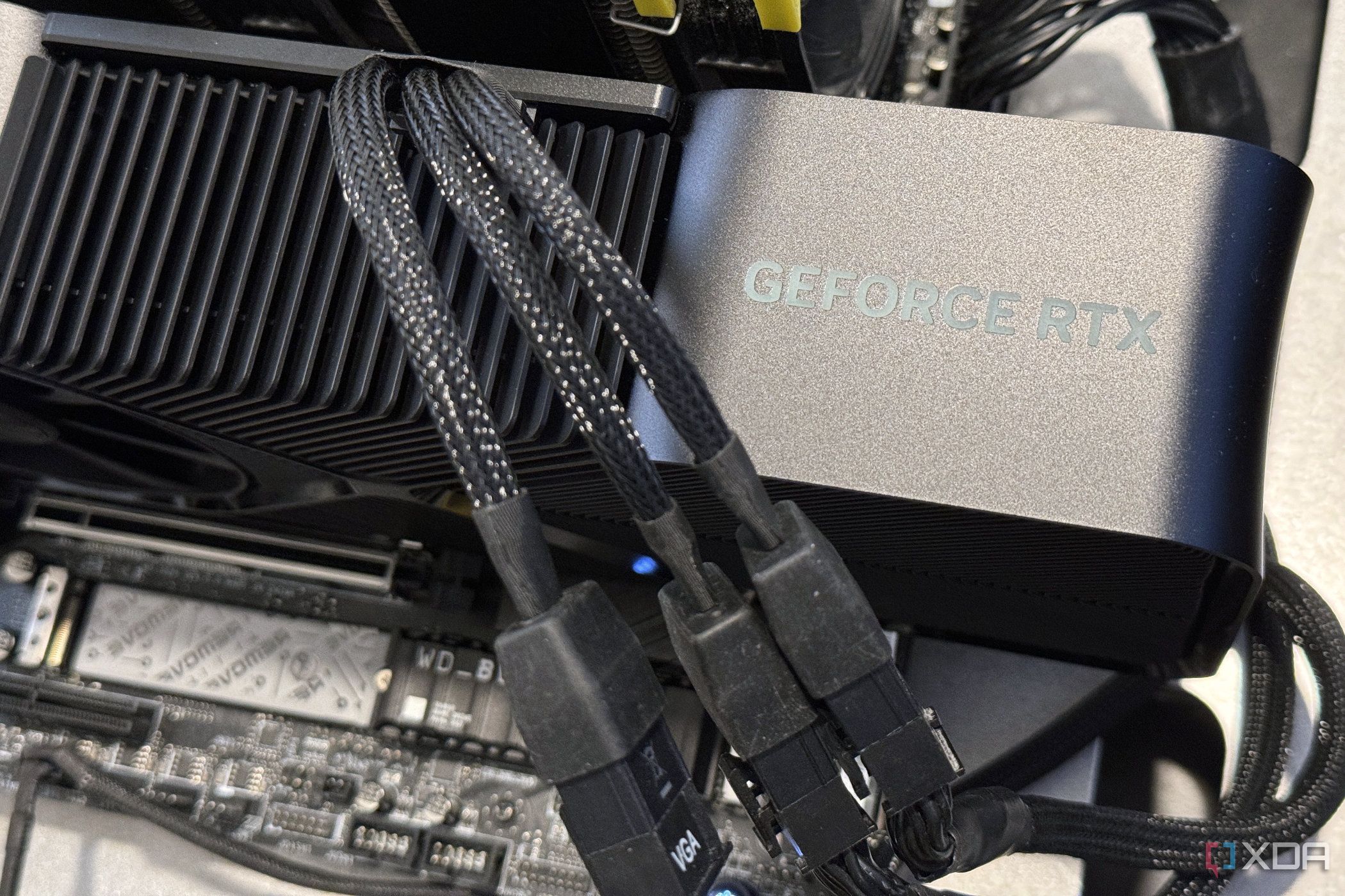 nvidia geforce rtx 4080 super graphics card installed in a motherboard showing three power cables going into its power adapter