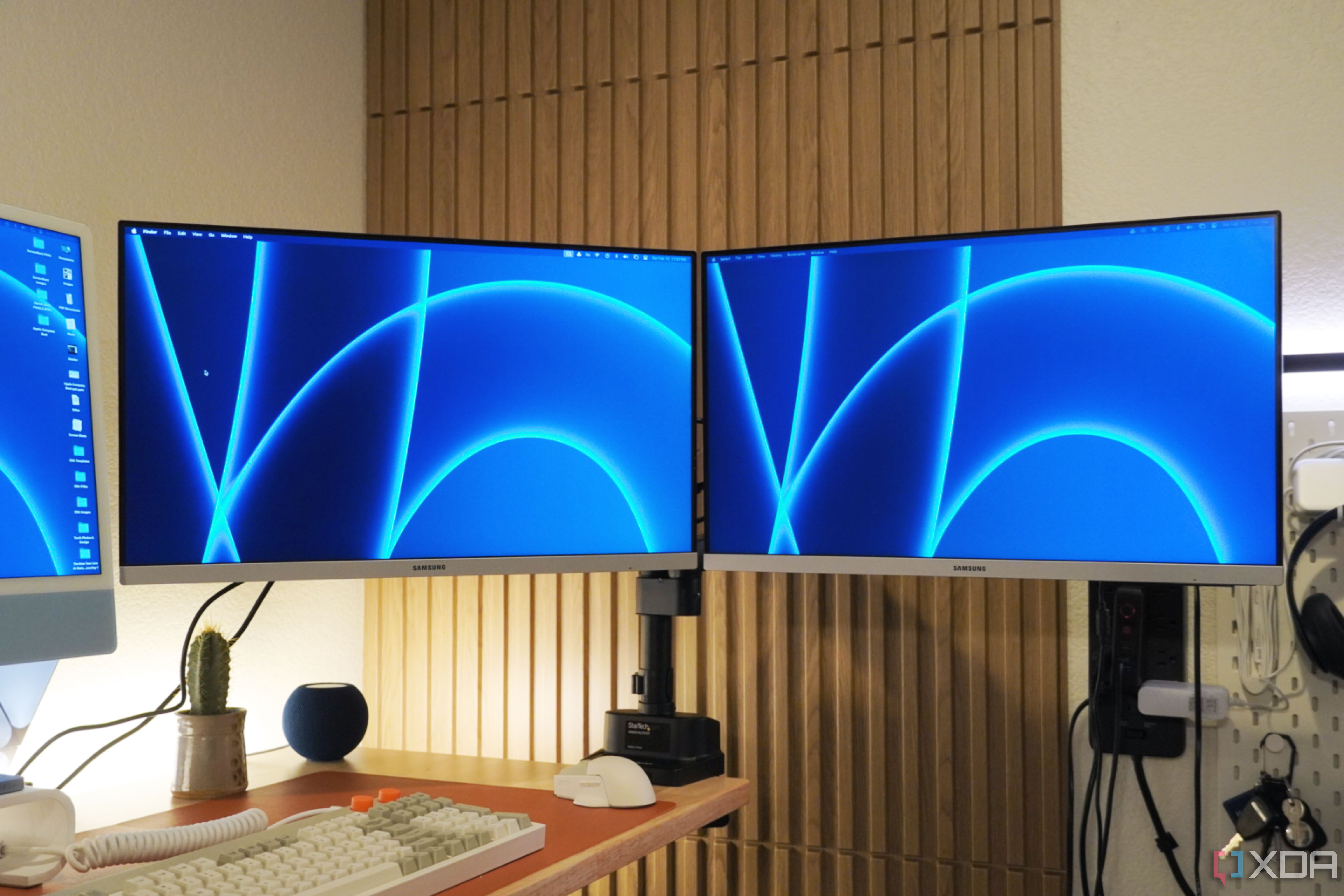 Two Samsung monitors mounted to a desk with the StarTech Dual Monitor Arm.