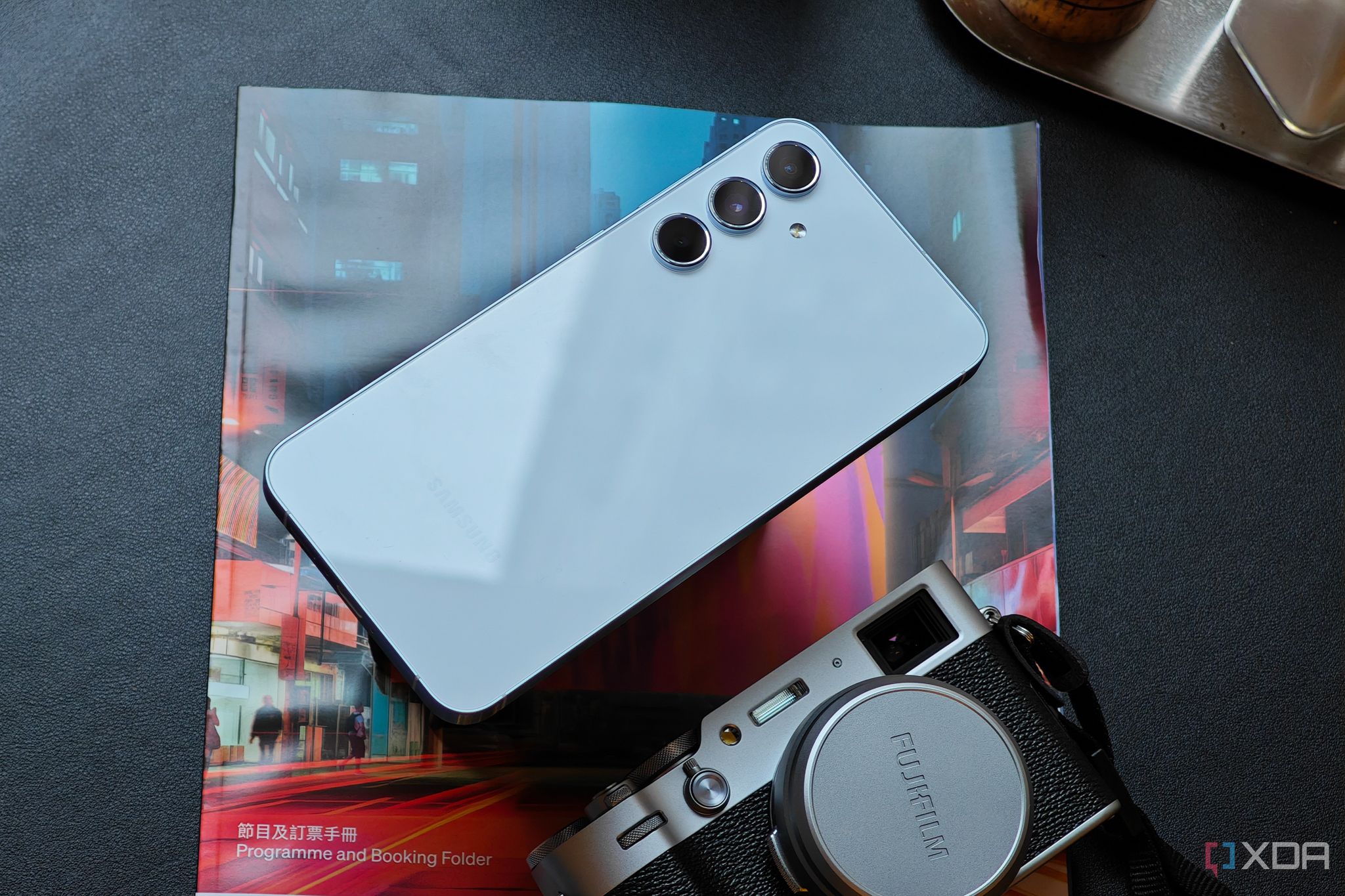 Galaxy A55 set on a magazine near a camera