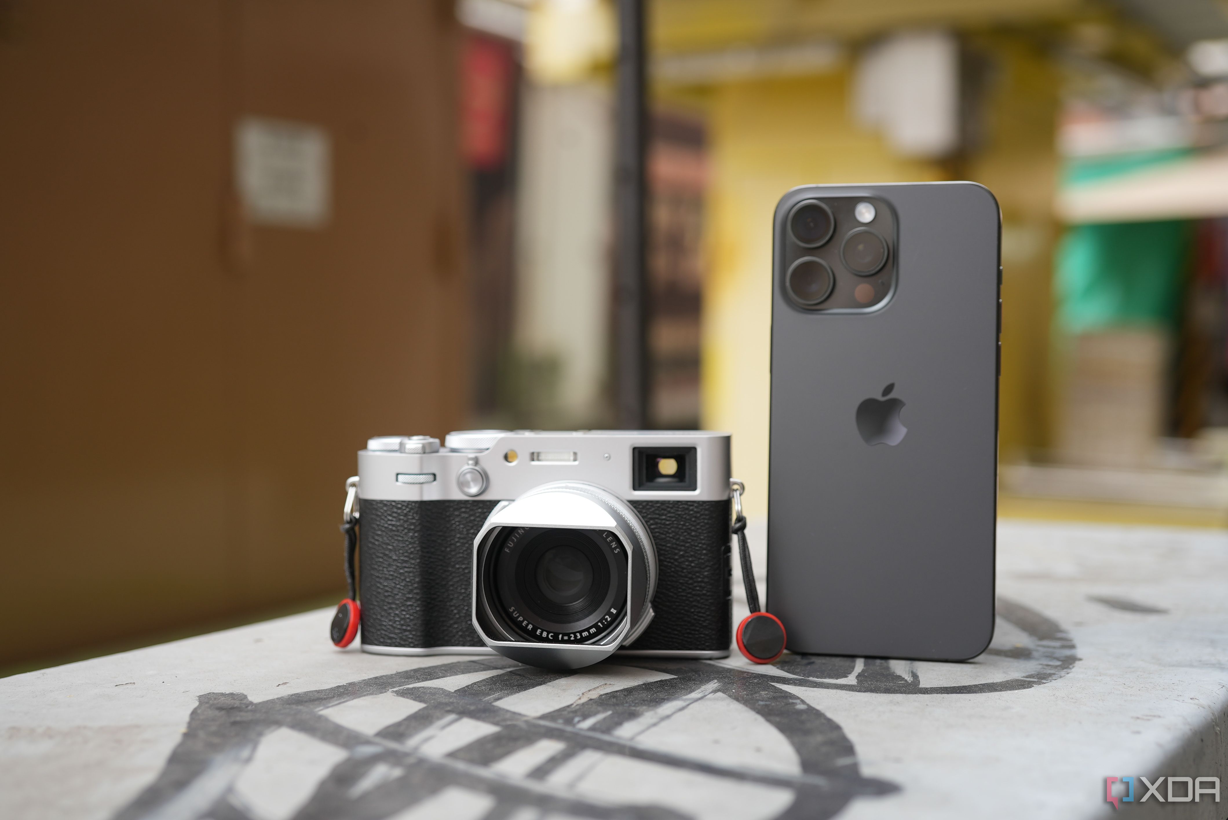 fujifilm x100 vi and iphone 15 pro max together side by side