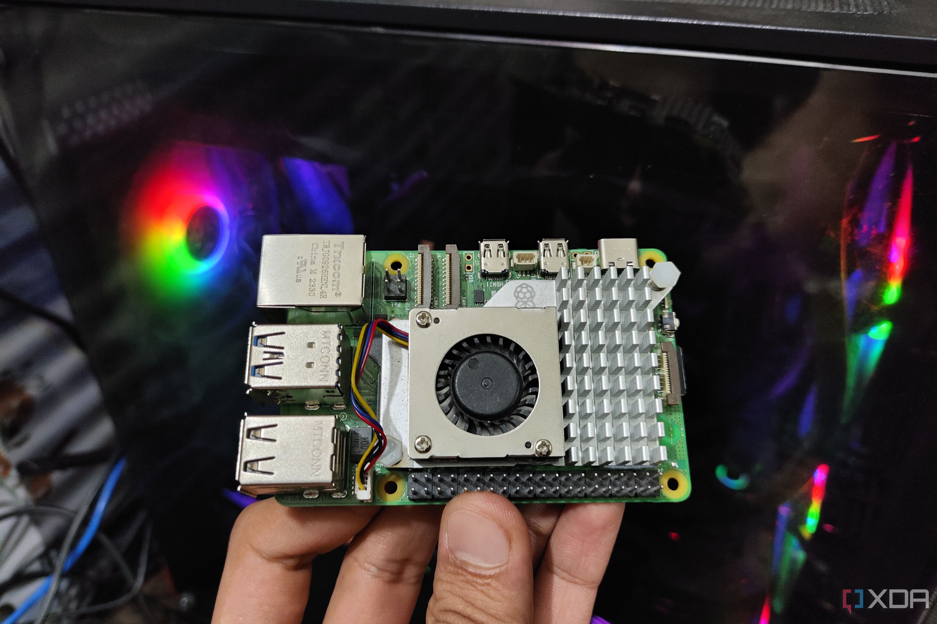 A Raspberry Pi 5 held in front of a PC