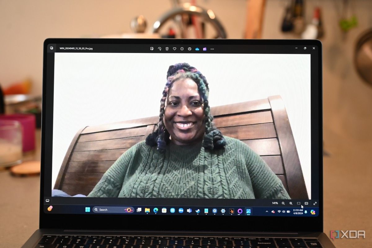 Captura de pantalla de una mujer afroamericana con un suéter verde tomada con una cámara web del Samsung Galaxy Book 4 Ultra