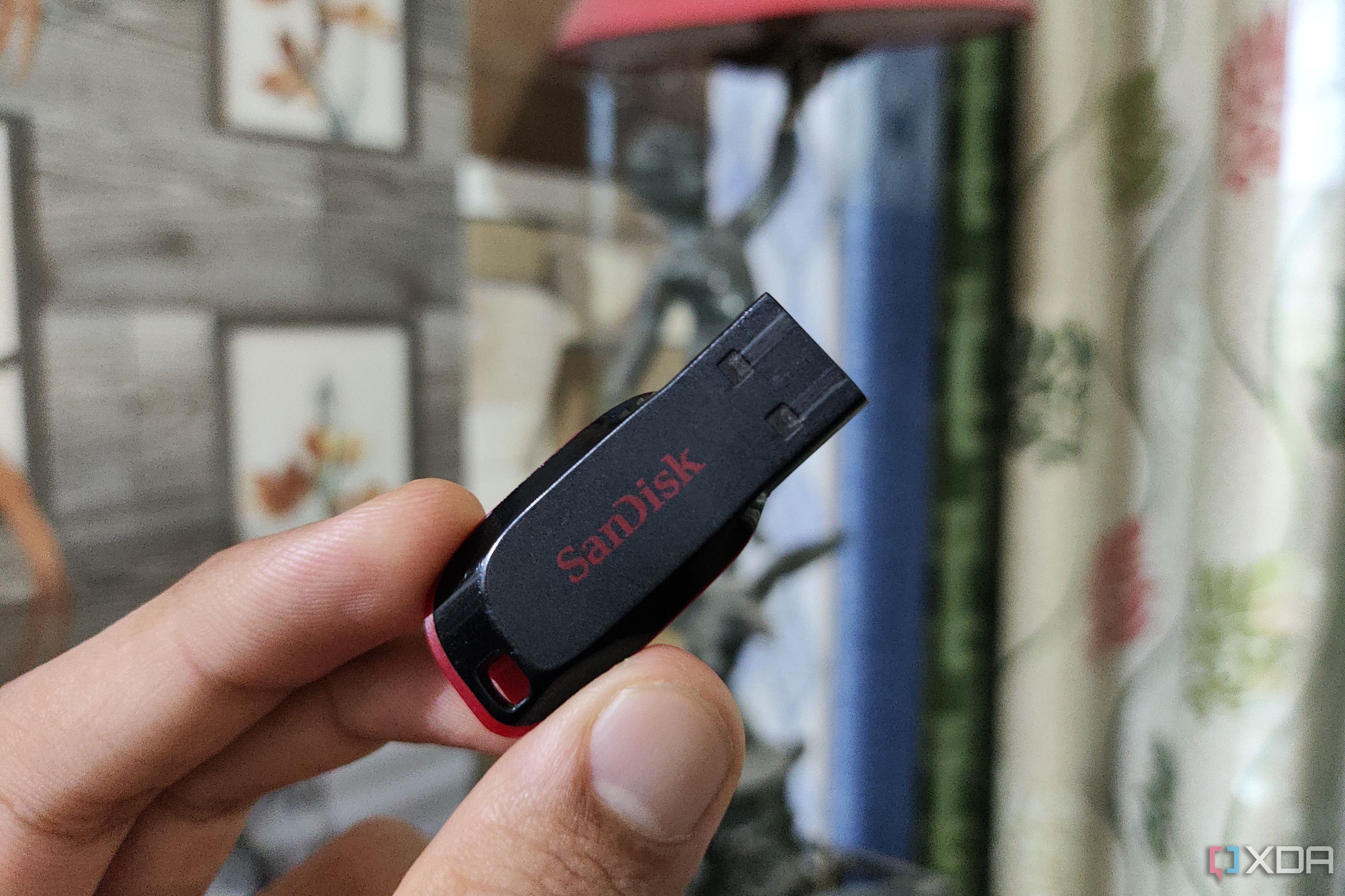 Una persona sosteniendo una unidad flash SanDisk