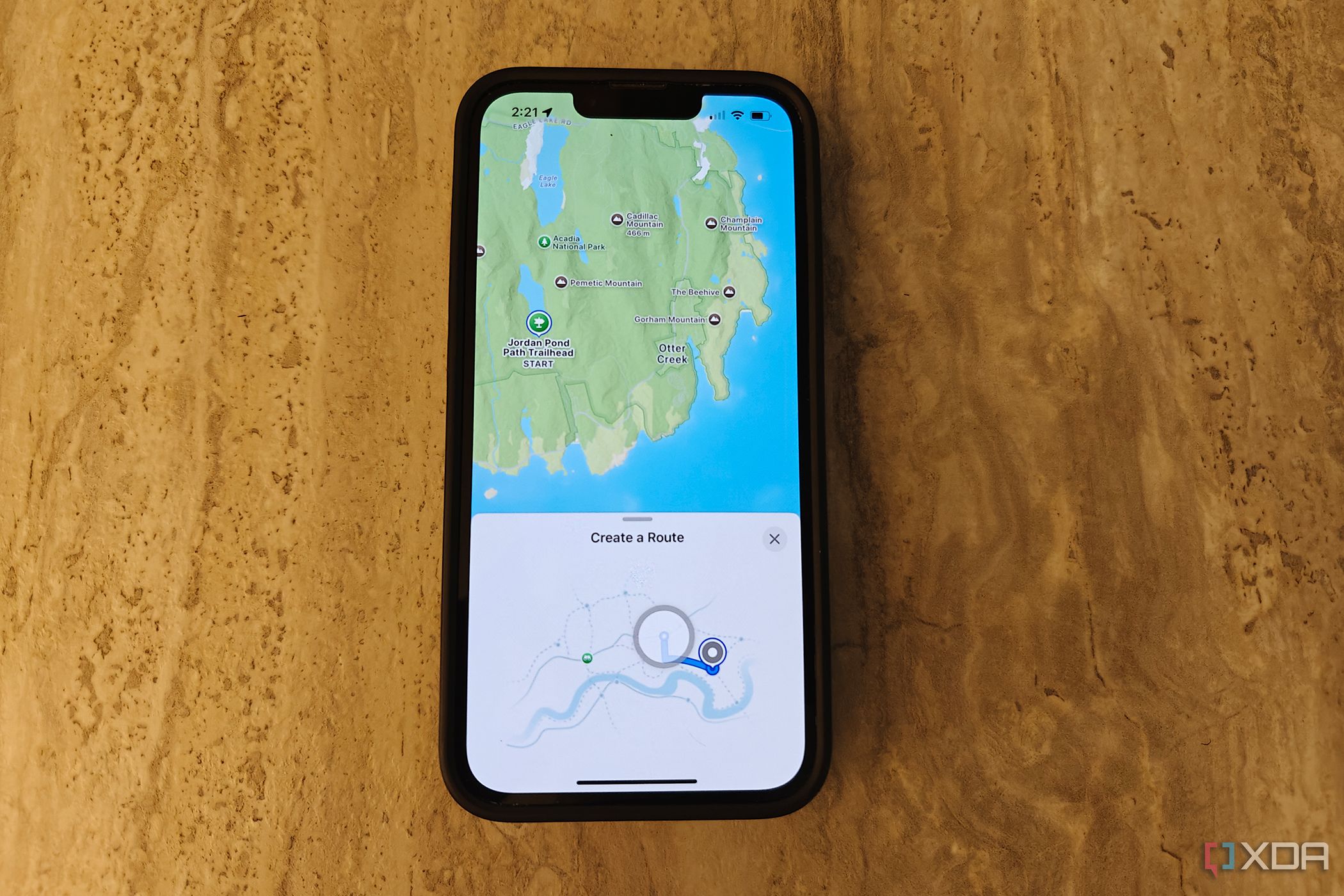 Un iPhone sobre una mesa con la aplicación Apple Maps abierta mostrando la opción de crear una ruta