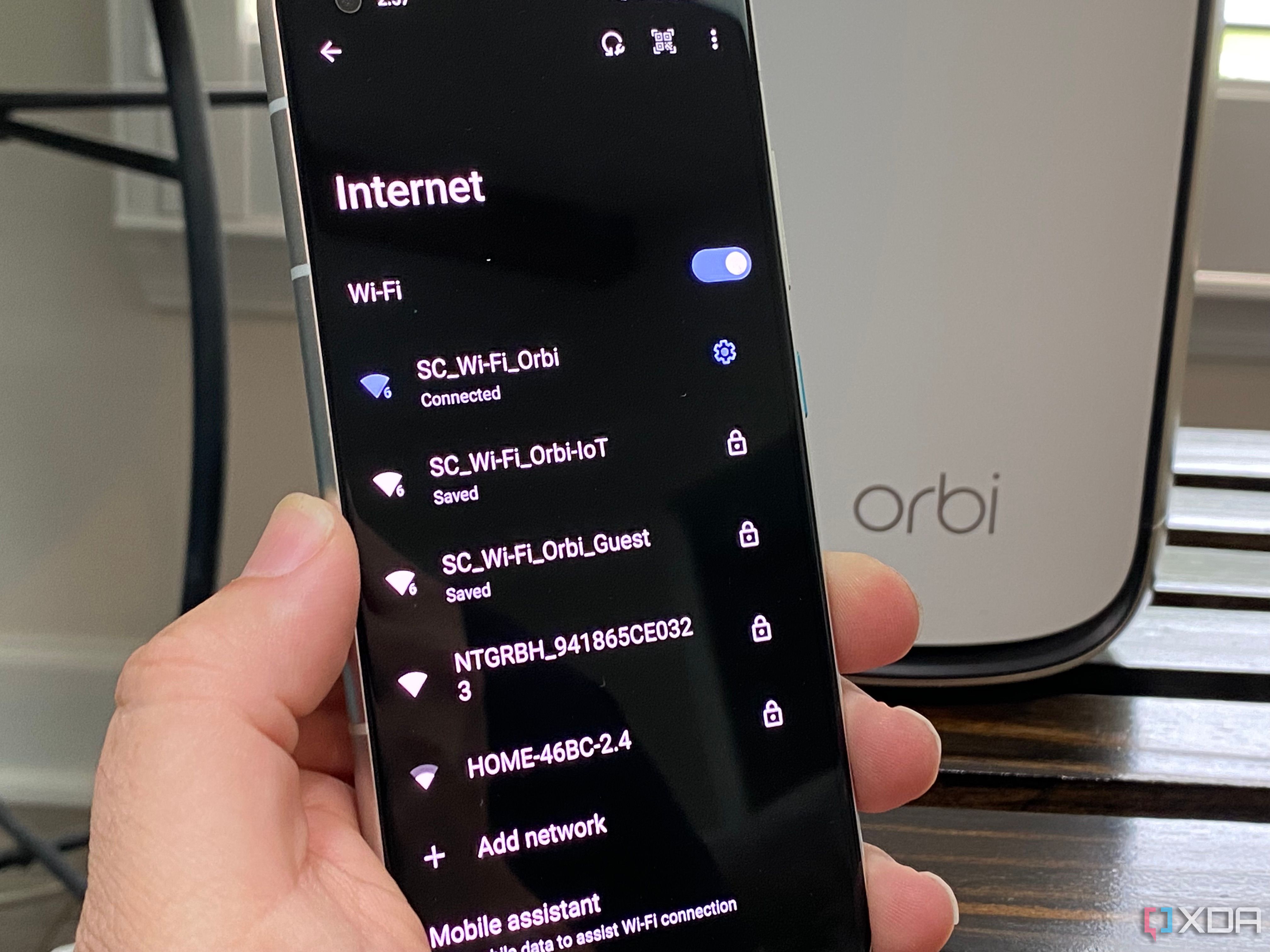 Netgear router with IoT, Guest, and standard Wi-Fi shown on an Android phone