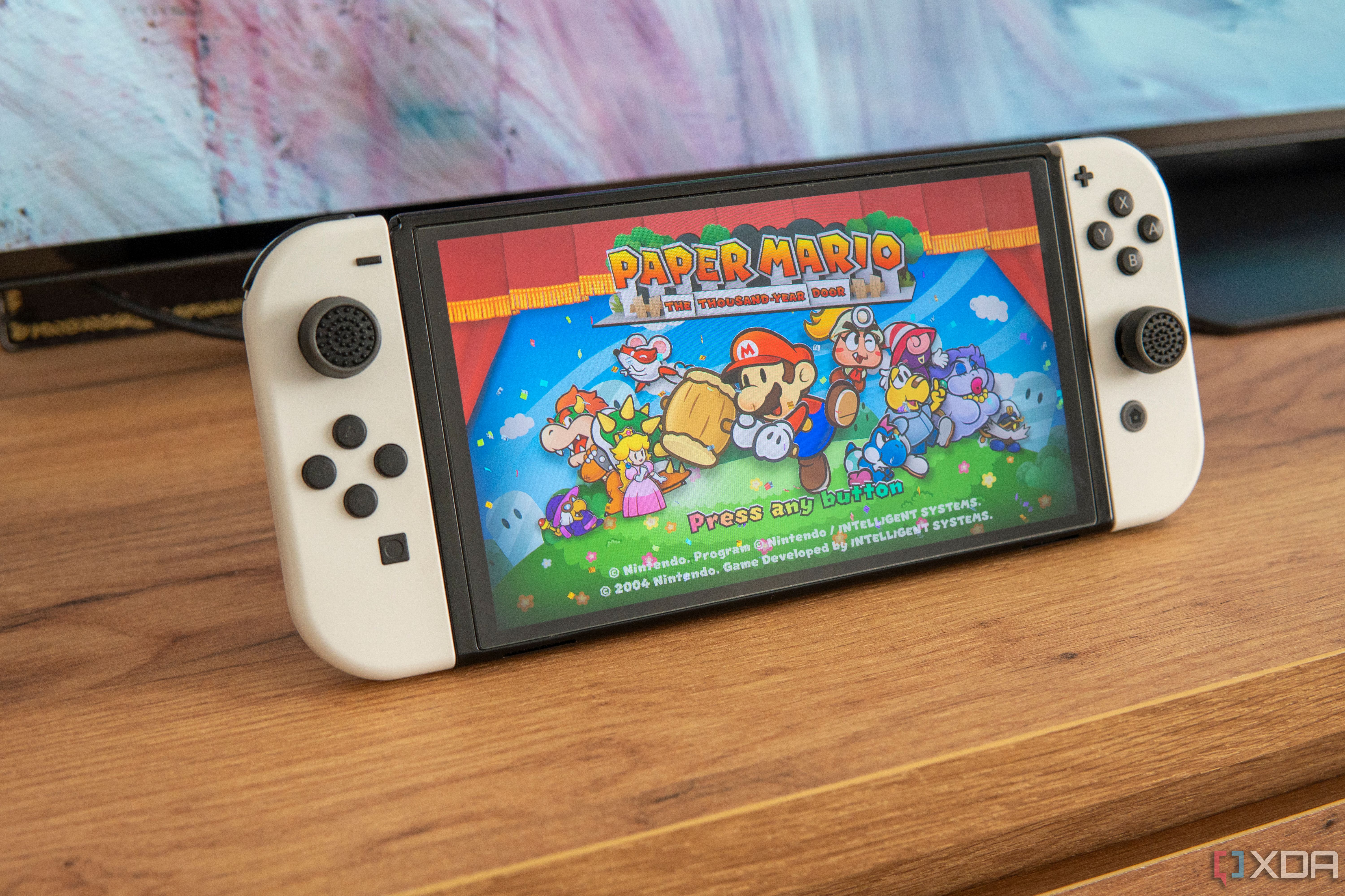 Vista en ángulo de una Nintendo Switch que muestra la pantalla de título de Paper Mario The Thousand Year Door