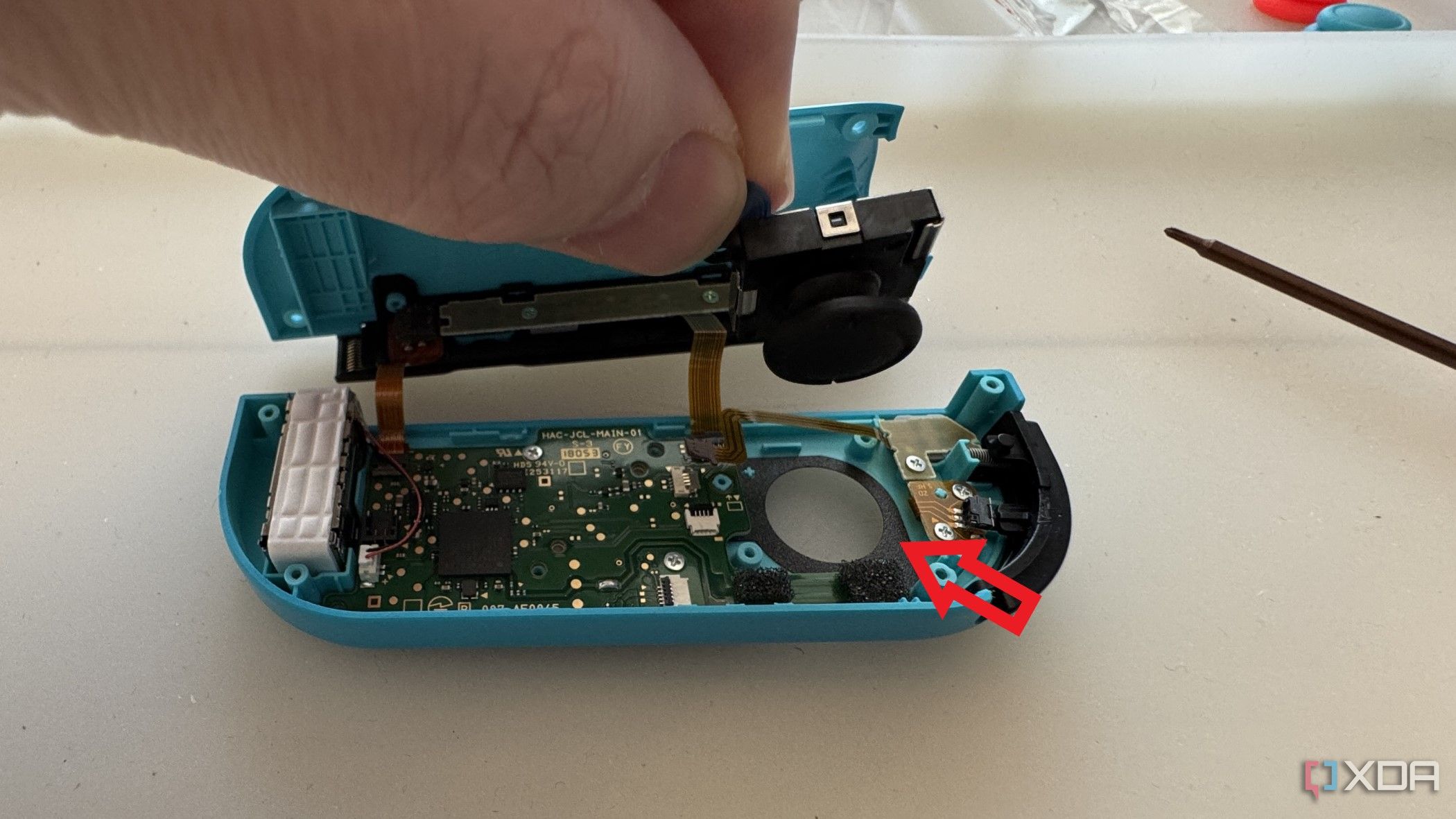 Interior del Joy-Con izquierdo de un Nintendo Switch que muestra la extracción del joystick