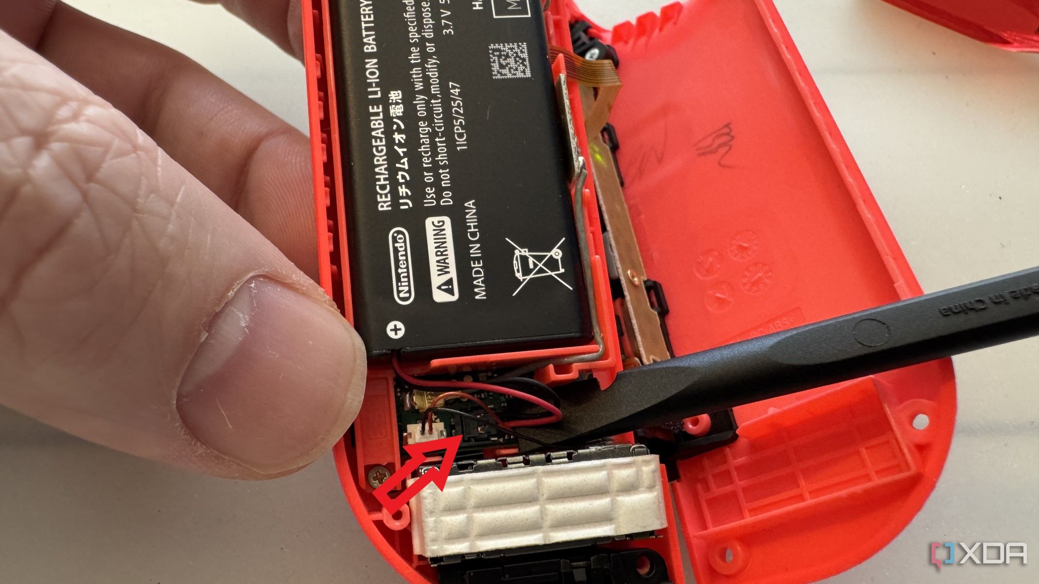 Conector de batería del Joy-Con derecho de Nintendo siendo levantado