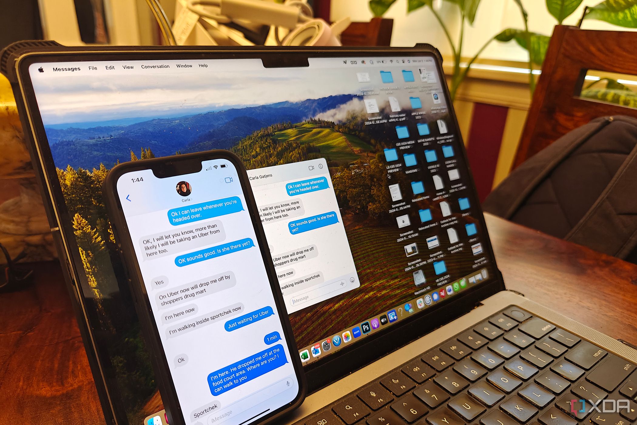 An iPhone propped up against a Mac, both showing the same iMessage window.