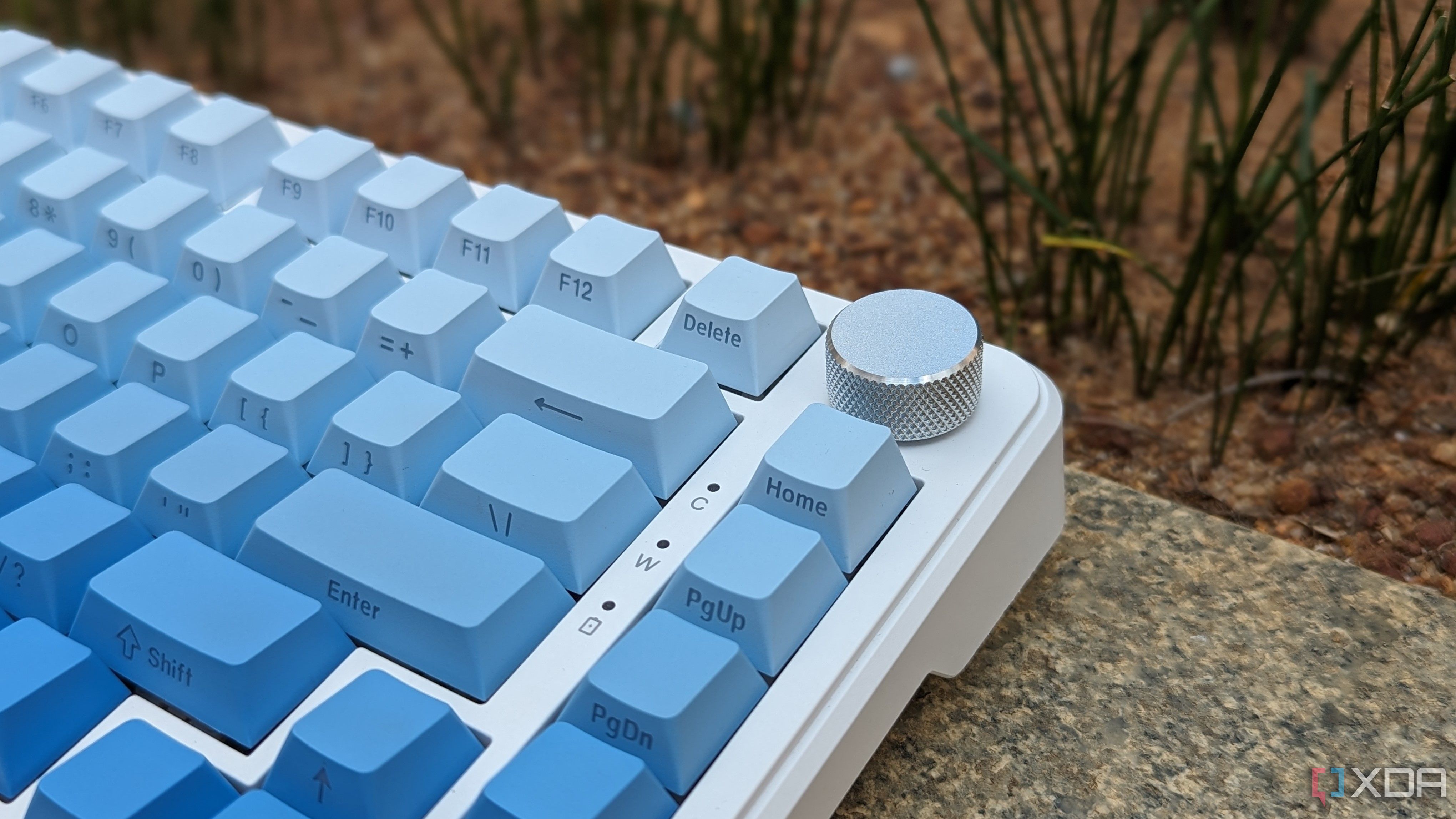 Un primer plano de un teclado azul-blanco que muestra luces indicadoras y una perilla