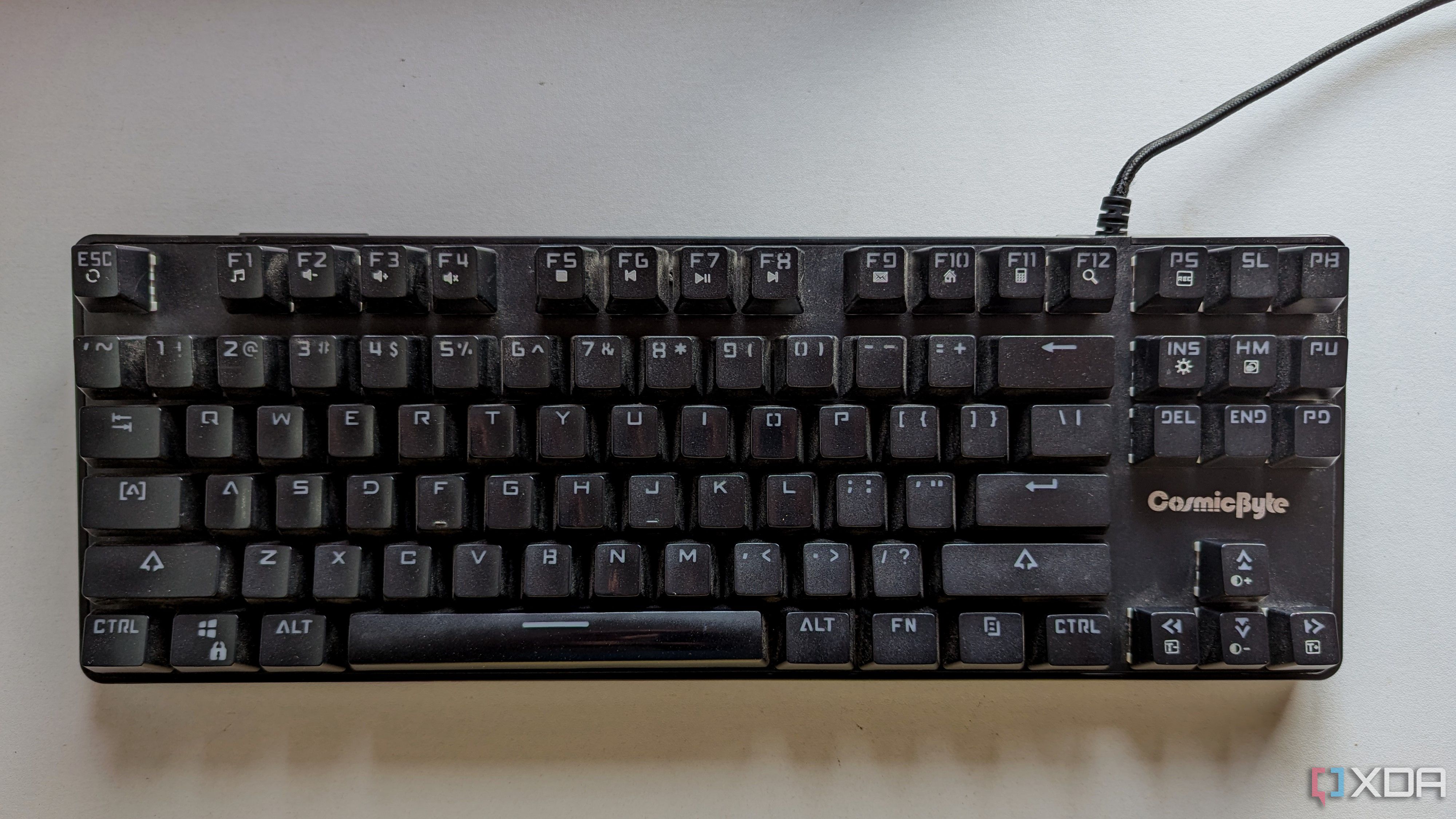 A black wired mechanical keyboard on a white surface