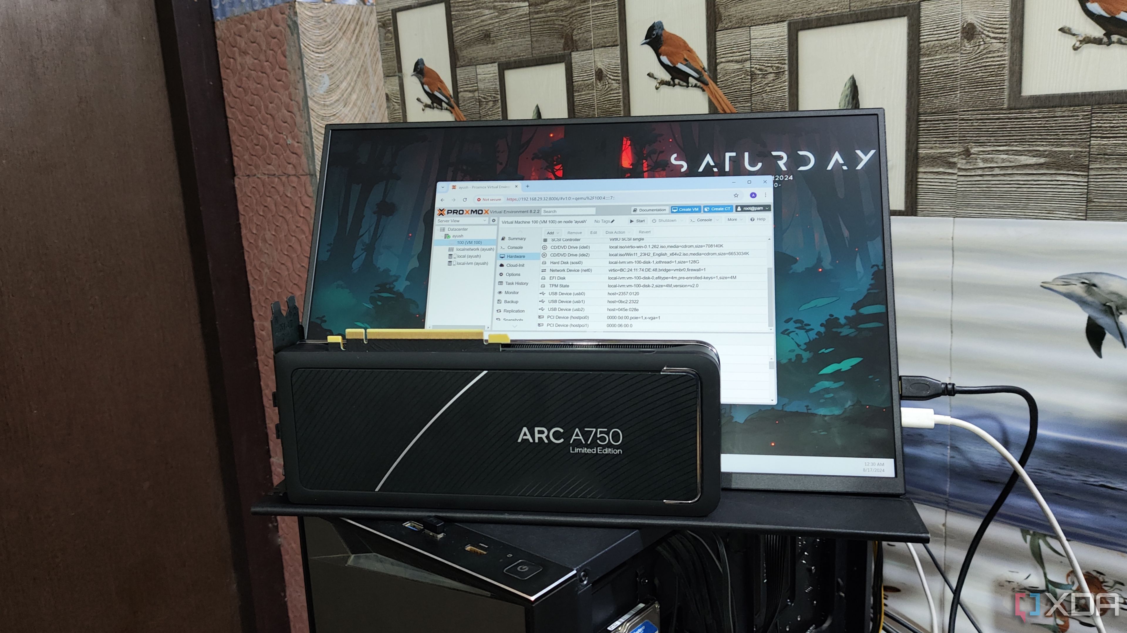 Una GPU Intel Arc A750 colocada frente a un monitor UGame K118 que muestra la interfaz web de Proxmox