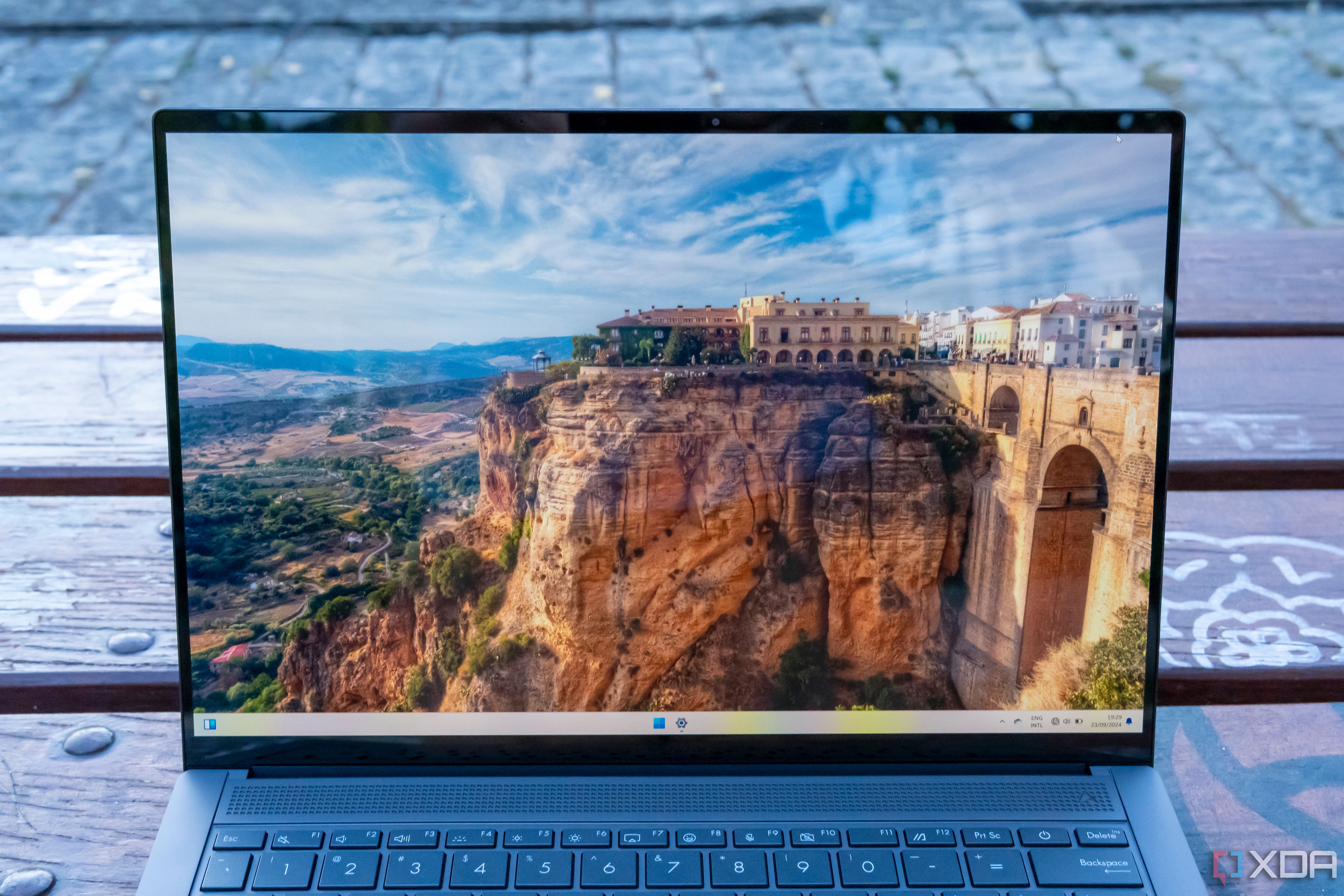 Vista frontal de la pantalla del Asus Zenbook S 14 que muestra una imagen de un acantilado con un monumento en la cima de la montaña