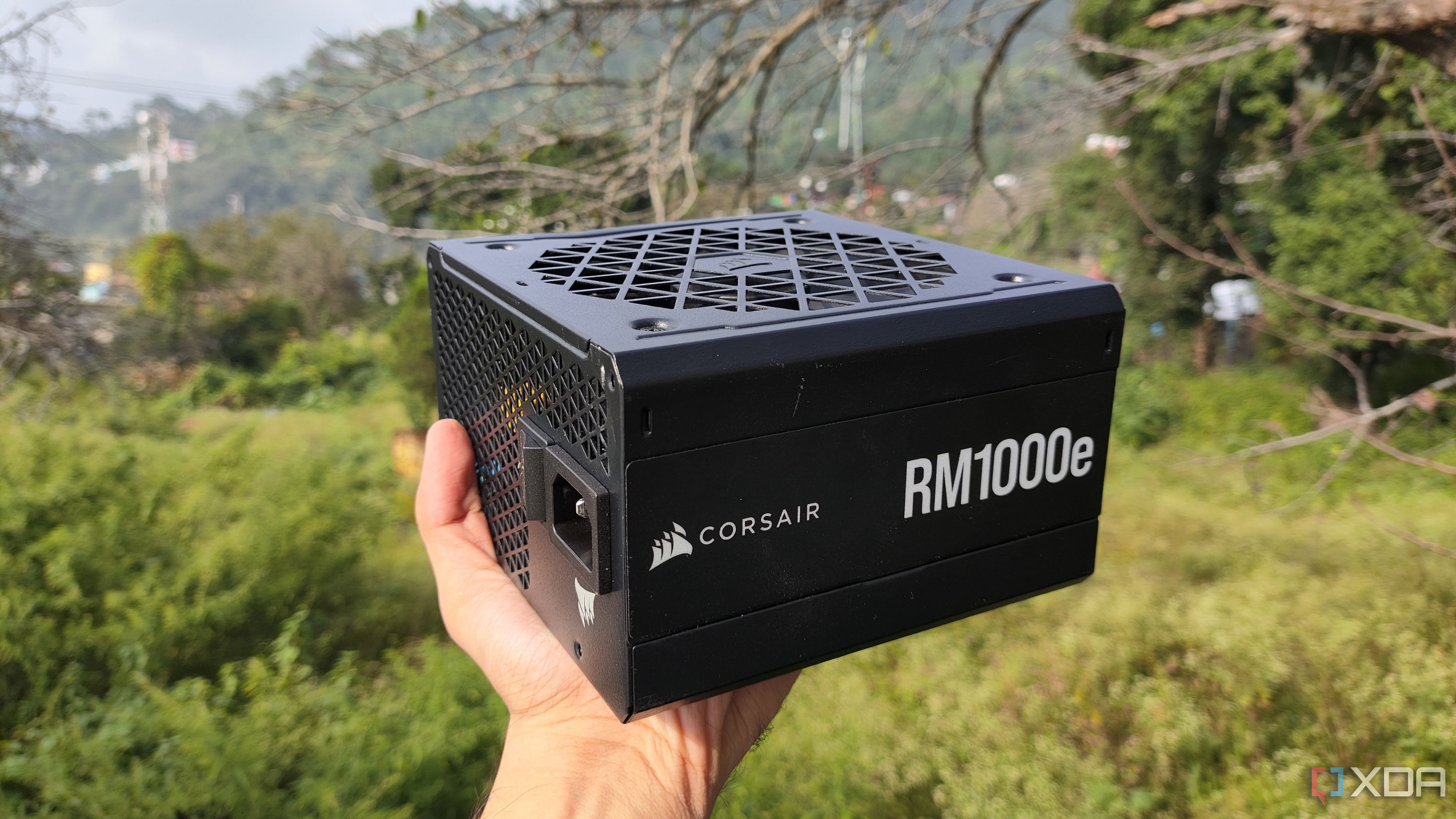 Una persona sosteniendo una fuente de alimentación Corsair RM1000e